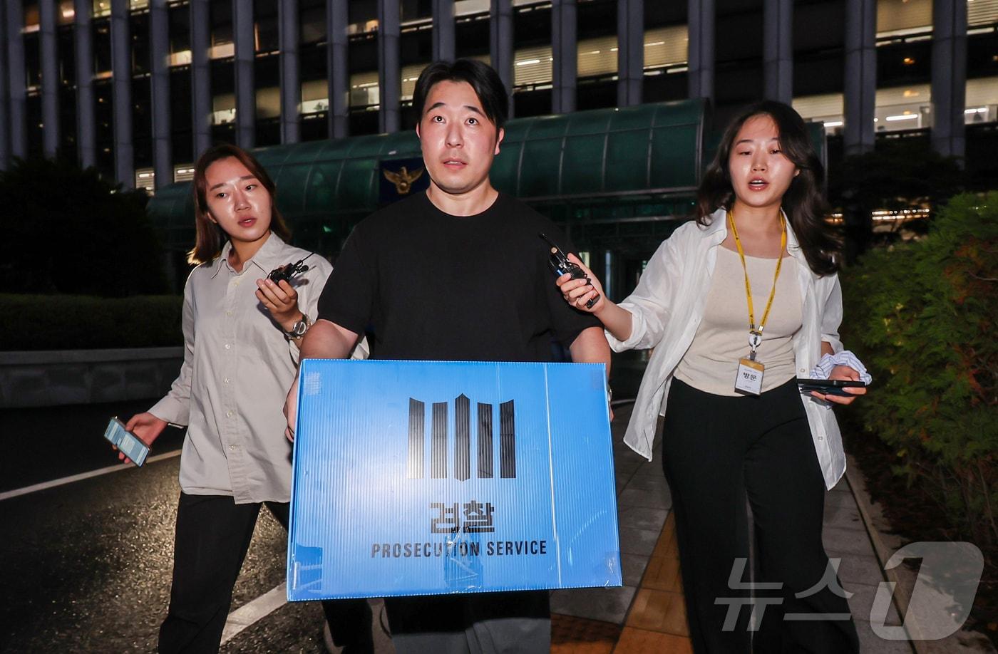본문 이미지 - 검찰 관계자들이 21일 오후 장윤기 사건 부실 수사와 증거인멸 의혹 등을 규명하기 위해 서울 서대문구 경찰청 국가수사본부에 대한 압수수색을 마친 뒤 압수품을 들고 건물을 빠져나오고 있다. 2026.7.21 ⓒ 뉴스1 김진환 기자