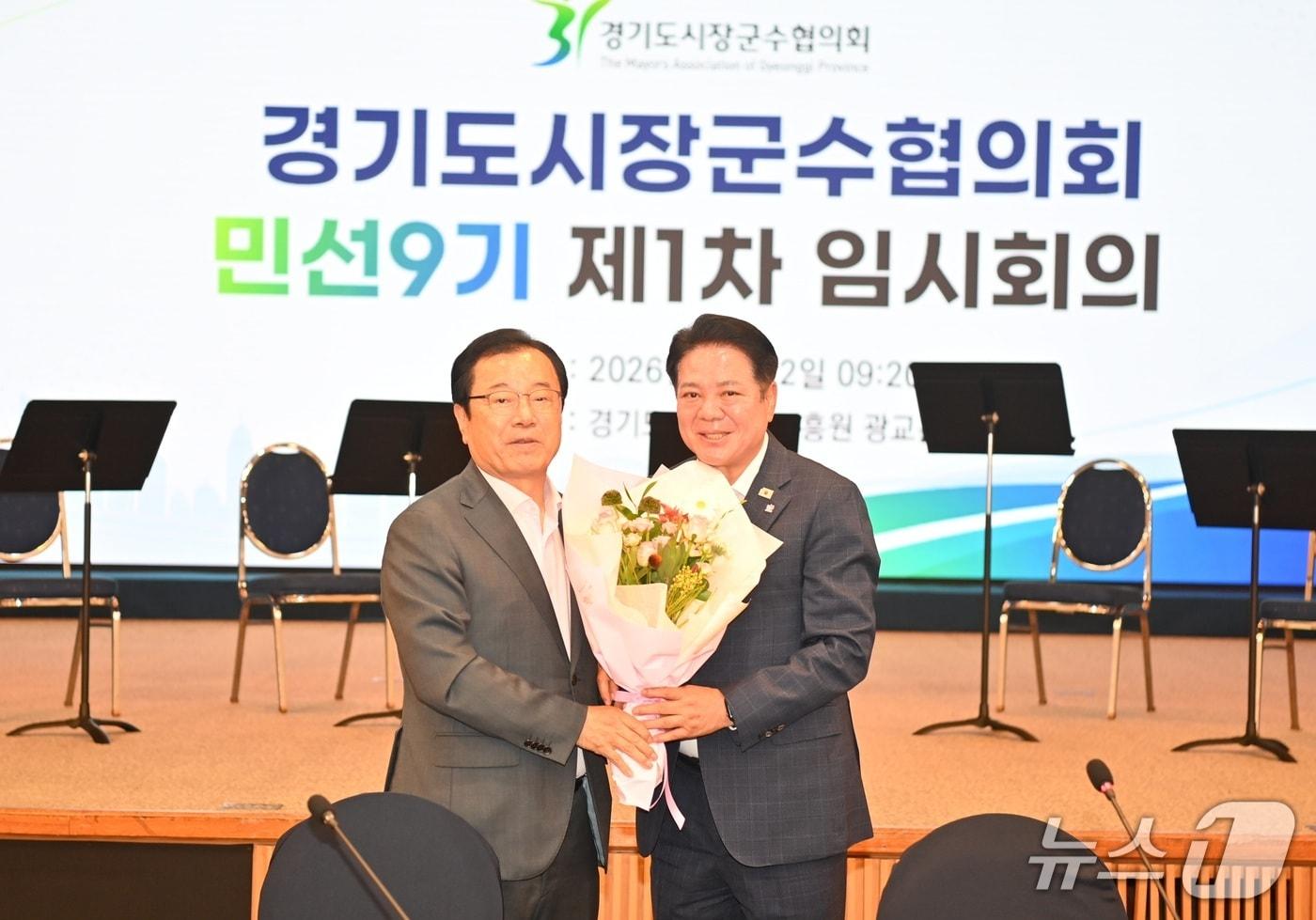 본문 이미지 - 9기 경기도시장군수협의회장으로 선출된 최대호 안양시장(오른쪽)이 임시회장으로서 회의를 진행한 이현재 하남시장으로부터 꽃다발을 받고 있다.(안양시 제공. 재판매 및 DB금지)/뉴스1