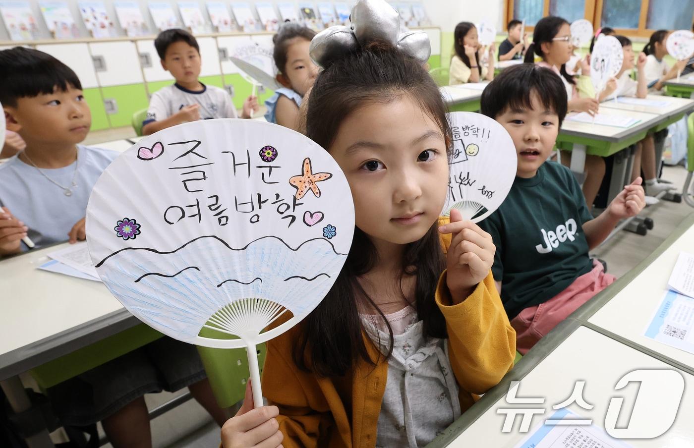 본문 이미지 - 서울지역 초등학교가 여름방학에 들어간 22일 서울 노원구 중평초등학교 2학년 2반에서 열린 여름 방학식에서 어린이들이 방학 목표가 적힌 부채를 들고 포즈를 취하고 있다. 2026.7.22 ⓒ 뉴스1 오대일 기자