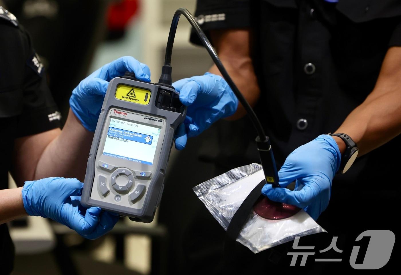 본문 이미지 - 22일 오전 인천국제공항 제1터미널 집중검사실에서 관세청 직원이 라만분광기를 이용해 마약밀수 적발장면을 시연하고 있다. (공동취재) 2026.7.22 ⓒ 뉴스1 박지혜 기자