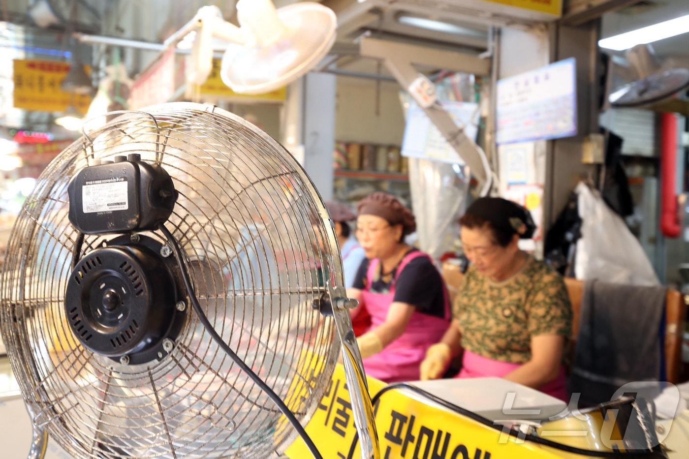 본문 이미지 - 22일 오후 전남광주통합특별시 서구 양동 양동시장에서 폭염 속 상인들이 선풍기를 틀며 음식 준비를 하고 있다. ⓒ 뉴스1 조수민 기자