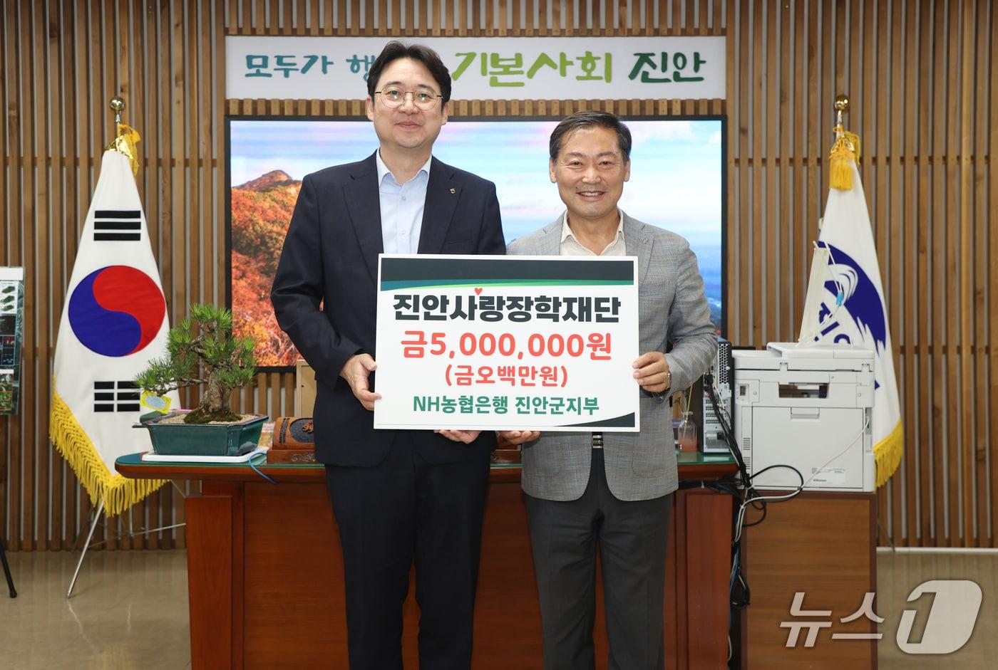 본문 이미지 - 한정호 NH농협은행 진안군지부장(왼쪽)이 진안사랑장학재단 이사장인 전춘성 군수에게 장학금 500만원을 전달하고 있다.(진안군제공, 재판매 및 DB금지)2026.7.22/뉴스1