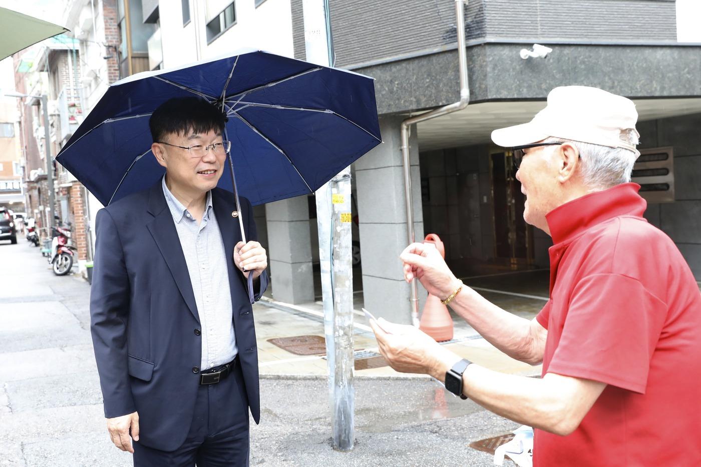 본문 이미지 - 22일 안형준 국가데이터처장이 폭우 속에서 서울 광진구 응답 가구를 만나고 있다. (국가데이터처 제공)