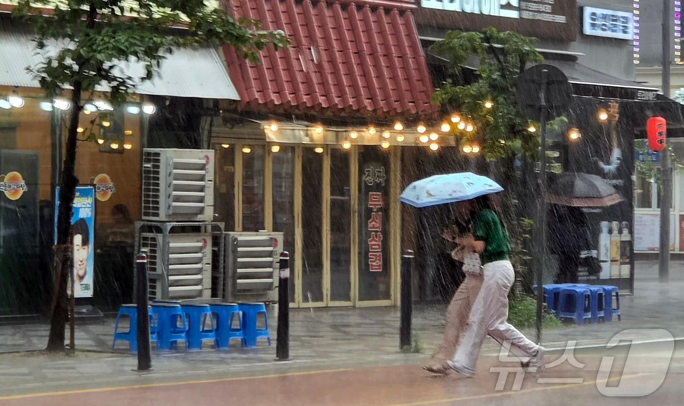 본문 이미지 - 22일 오후 세종 나성동 인근에 거센 장맛비가 내려 시민들이 비를 피하고 있다. 2026.7.22 ⓒ 뉴스1 황덕현 기후환경전문기자