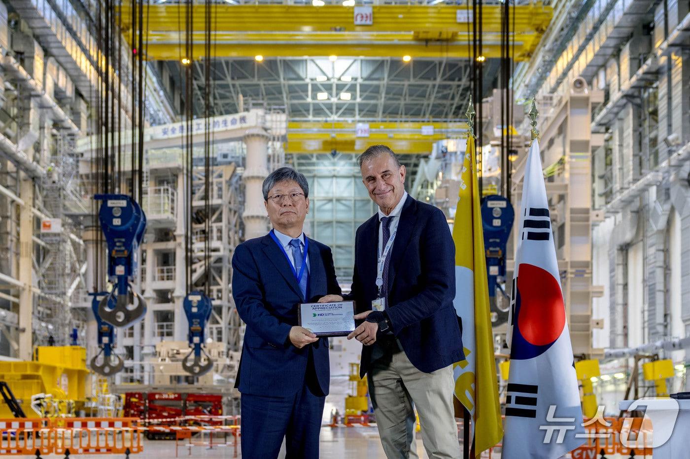 본문 이미지 - 프랑스 남부 카다라슈의 국제핵융합실험로(ITER) 건설 현장에서 22일(현지시각) 열린 '코리아-ITER 퓨전 데이' 행사에서 원광식 HD현대중공업 부사장(왼쪽)이 피에트로 바라바쉬 ITER 사무총장(오른쪽)으로부터 감사패를 받고 있다(HD현대중공업 제공). 2026.7.22.