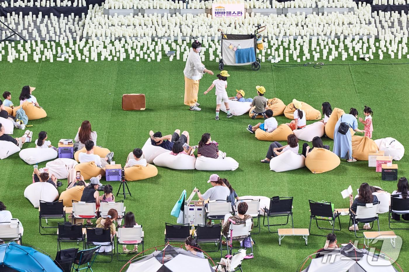 본문 이미지 - 지난 18일 '2026 대한민국 밤밤페스타 IN 부산' 행사 방문객들이 빈백에 앉아 기증 도서를 읽고 있다.(부산관광공사 제공. 재판매 및 DB금지)