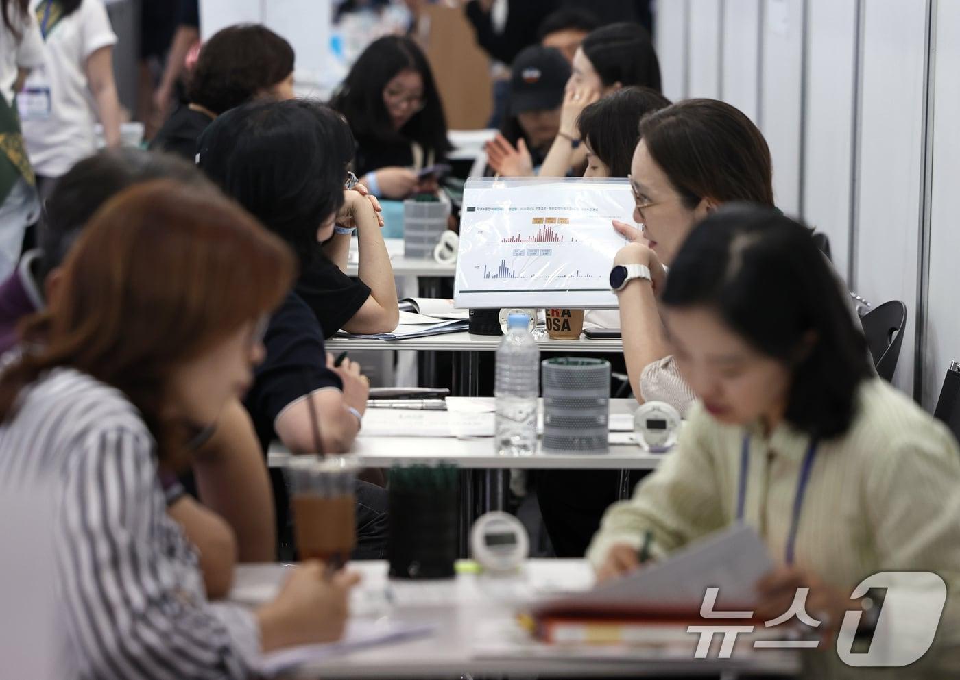 본문 이미지 - 23일 서울 강남구 코엑스에서 열린 '2027학년도 수시대학입학정보박람회'에서 학부모와 학생들이 입시상담을 하고 있다. 2026.7.23 ⓒ 뉴스1 구윤성 기자