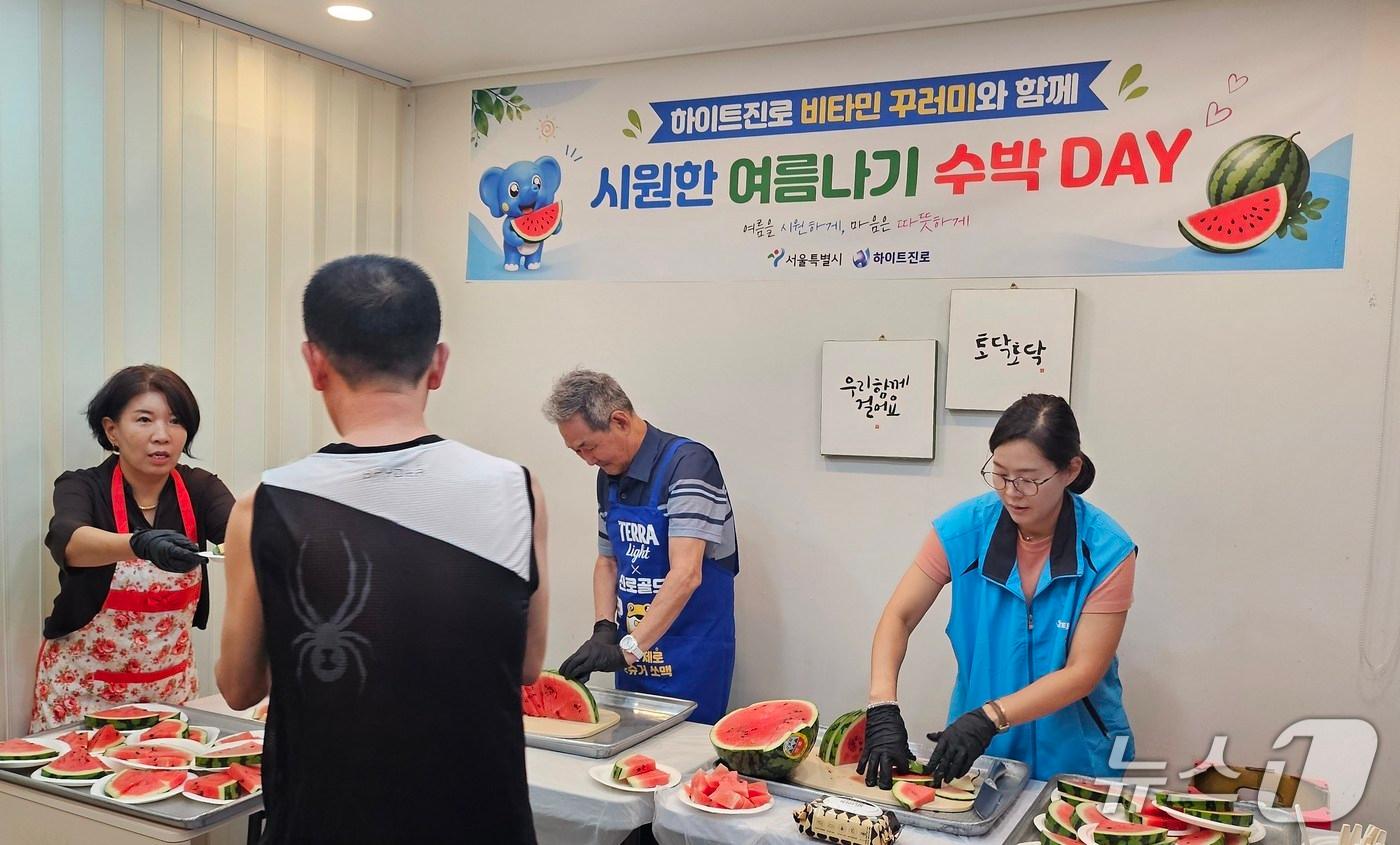 본문 이미지 - 시원한 여름나기 수박데이 행사장에서 서울역쪽방상담소 및 ㈜하이트진로 관계자와 주민이 함께 나눠먹을 수박을 준비하고 있다.