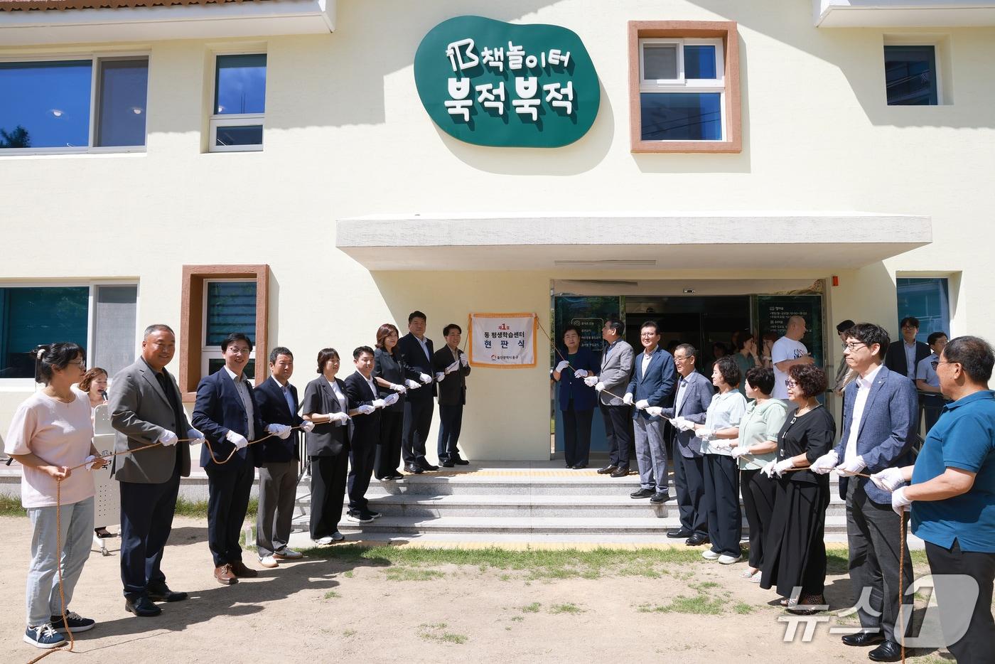 본문 이미지 - 23일 오전 울산 동구 서부동 '책 놀이터 북적북적'에서 열린 동구 제1호 동 평생학습센터 현판 제막식에서 동구 관계자들이 기념사진을 촬영하고 있다.(울산 동구 제공. 재판매 및 DB금지)/뉴스1