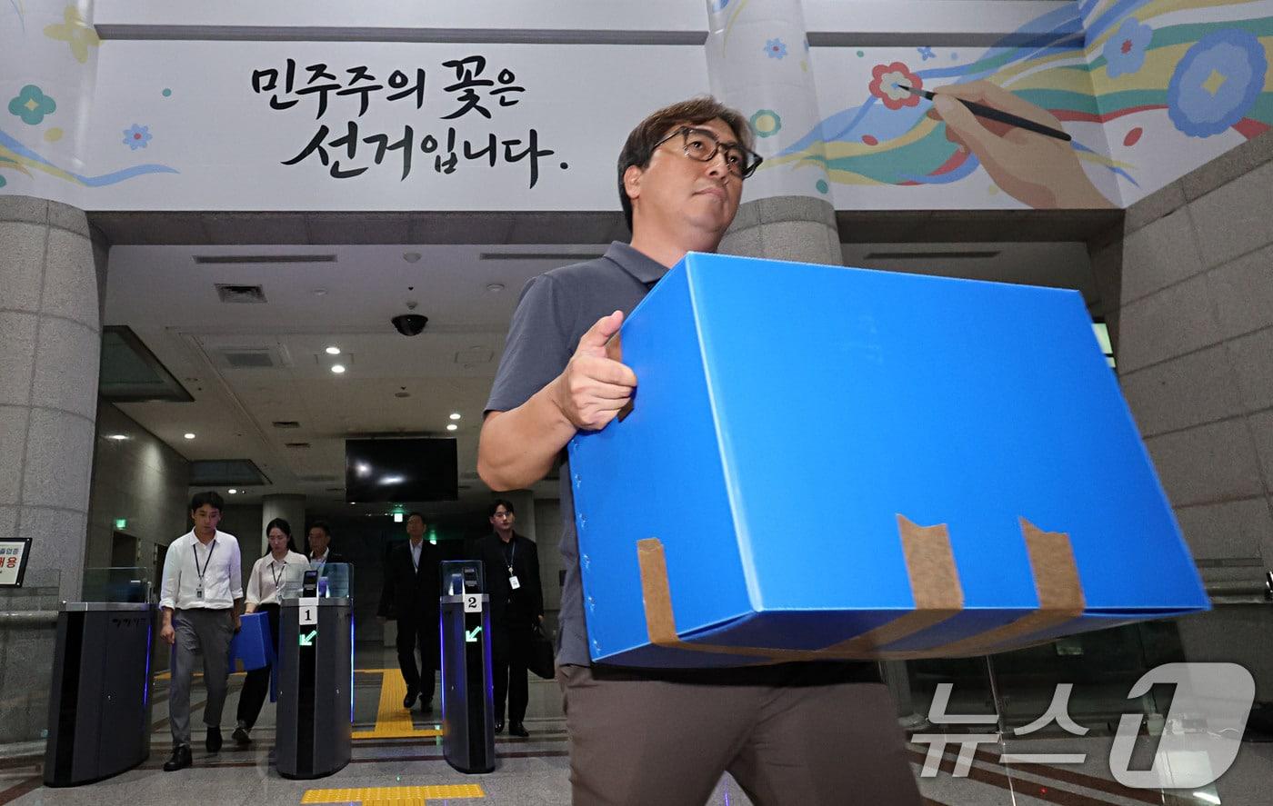 본문 이미지 - 6·3 지방선거 투표용지 부족 사태를 수사 중인 검·경 합동수사본부 관계자들이 23일 오후 경기 과천시 중앙선거관리위원회에 대한 압수수색을 마친뒤 압수상자를 들고 나서고 있다. (공동취재) 2026.7.23 ⓒ 뉴스1 이광호 기자