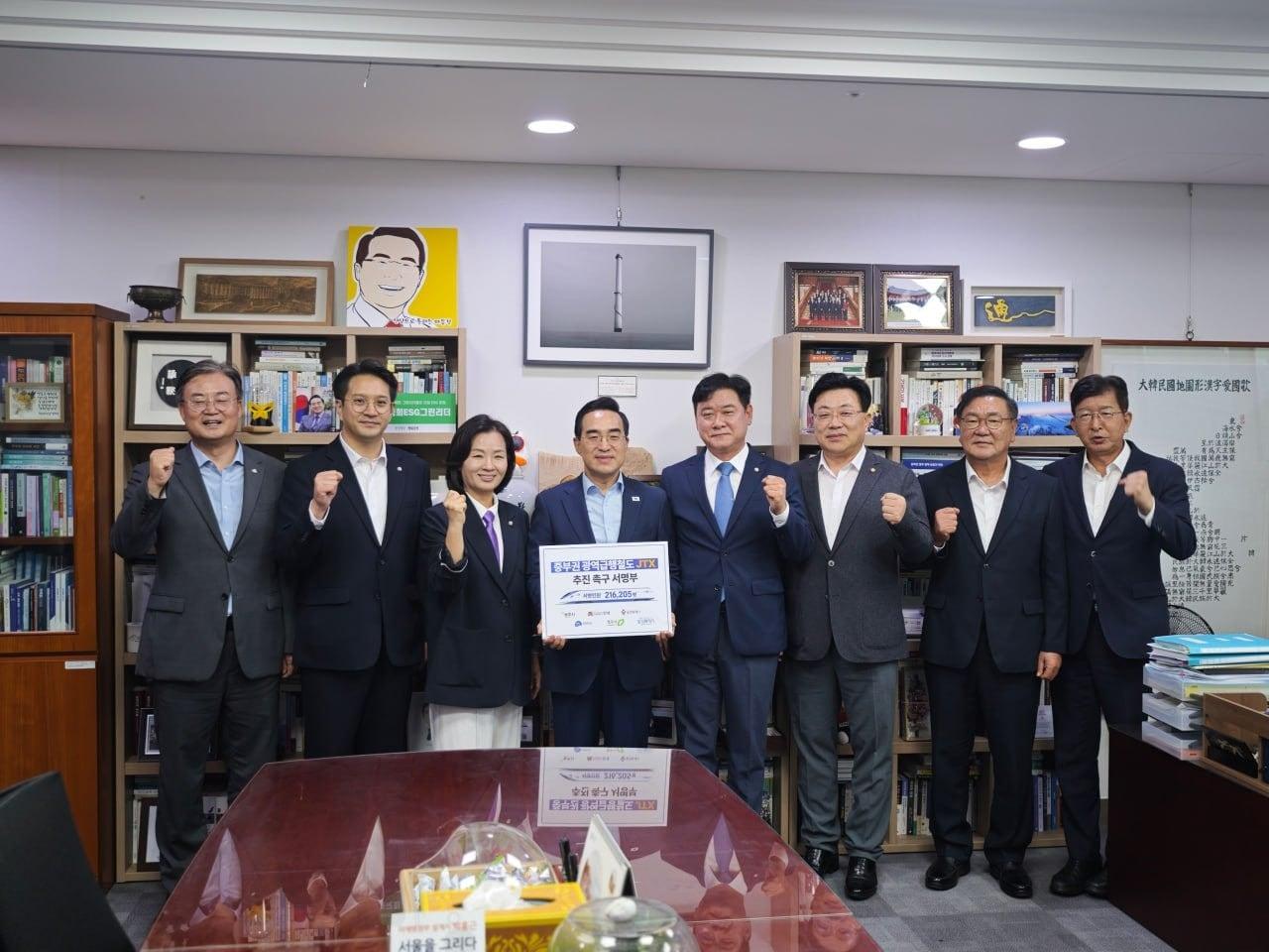 본문 이미지 - 윤종군 의원(왼쪽에서 5번째)등 국회의원들이 박홍근 기획예산처 장관(왼쪽에서 4번째)에게 23일 국회에서 JTX 조기 추진 촉구 시민 명부를 전달한 후 기념촬영을 하고 있다.(윤종군 의원실 제공)뉴스1ⓒ news1