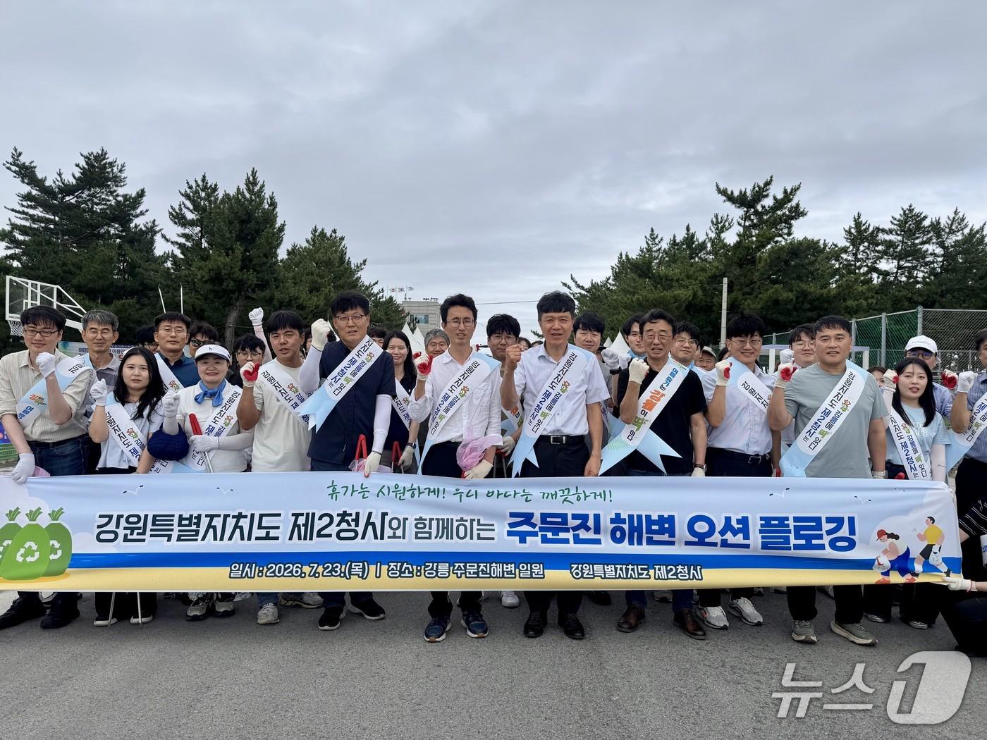 본문 이미지 - 강원도제2청사 직원들이 지난 23일 주문진해수욕장 일원에서 백사장을 걸으며 쓰레기를 줍는 '오션 플로깅(Ocean Plogging)' 봉사활동을 실시하고 기념촬영을 하고 있다.(강원도 제2청사 제공, 재판매 및 DB 금지) 2026.7.24/뉴스1