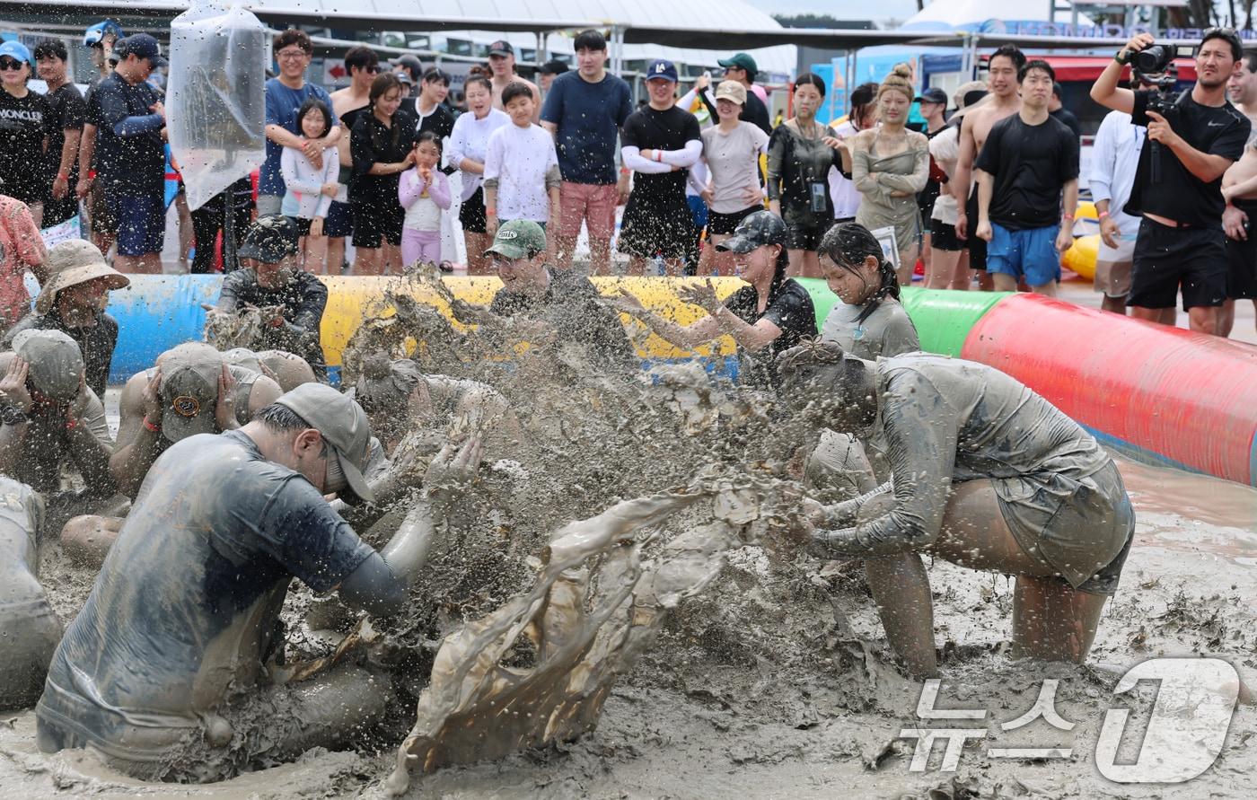 본문 이미지 - 28일 폭염특보가 발효된 대전·충남은 낮 최고체감온도가 33도 안팎까지 오르는 무더위가 이어질 것으로 예보됐다. 보령 대천해수욕장 머드엑스포광장에 마련된 축제장에서 외국인 등 관광객들이 즐거운 시간을 보내고 있다. ⓒ 뉴스1 김기태 기자