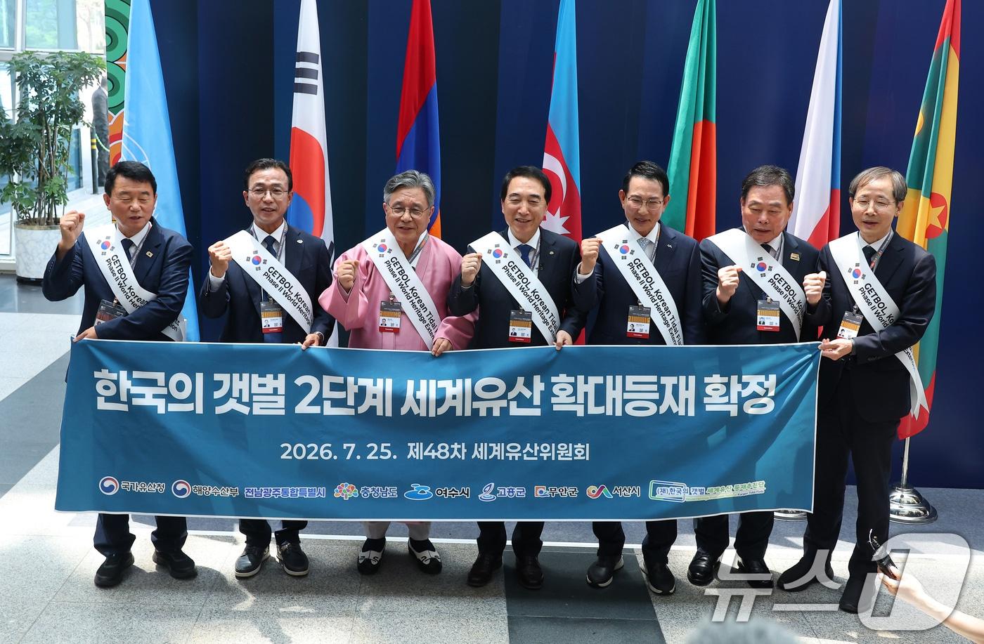 본문 이미지 - 25일 부산 해운대구 벡스코에서 열린 제48차 유네스코 세계유산위원회 본회의에서 '한국의 갯벌'(Getbol, Korean Tidal Flats) 2단계 등재가 확정되자 허민 국가유산청장과 박수현 충남도지사, 갯벌 등재 지역 단체장들이 축하 현수막과 함께 기념 촬영을 하고 있다.  2026.7.25 ⓒ 뉴스1 부산사진공동취재단