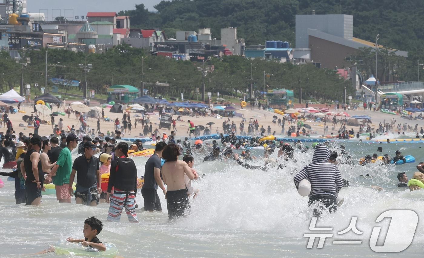 본문 이미지 - 27일 폭염특보가 발효된 대전·충남은 낮 최고체감온도가 33도 안팎까지 오르는 무더위가 이어질 것으로 예보됐다. 충남 보령 대천해수욕장에서 관광객들이 주말을 맞아 즐거운 시간을 보내고 있다.  ⓒ 뉴스1 김기태 기자