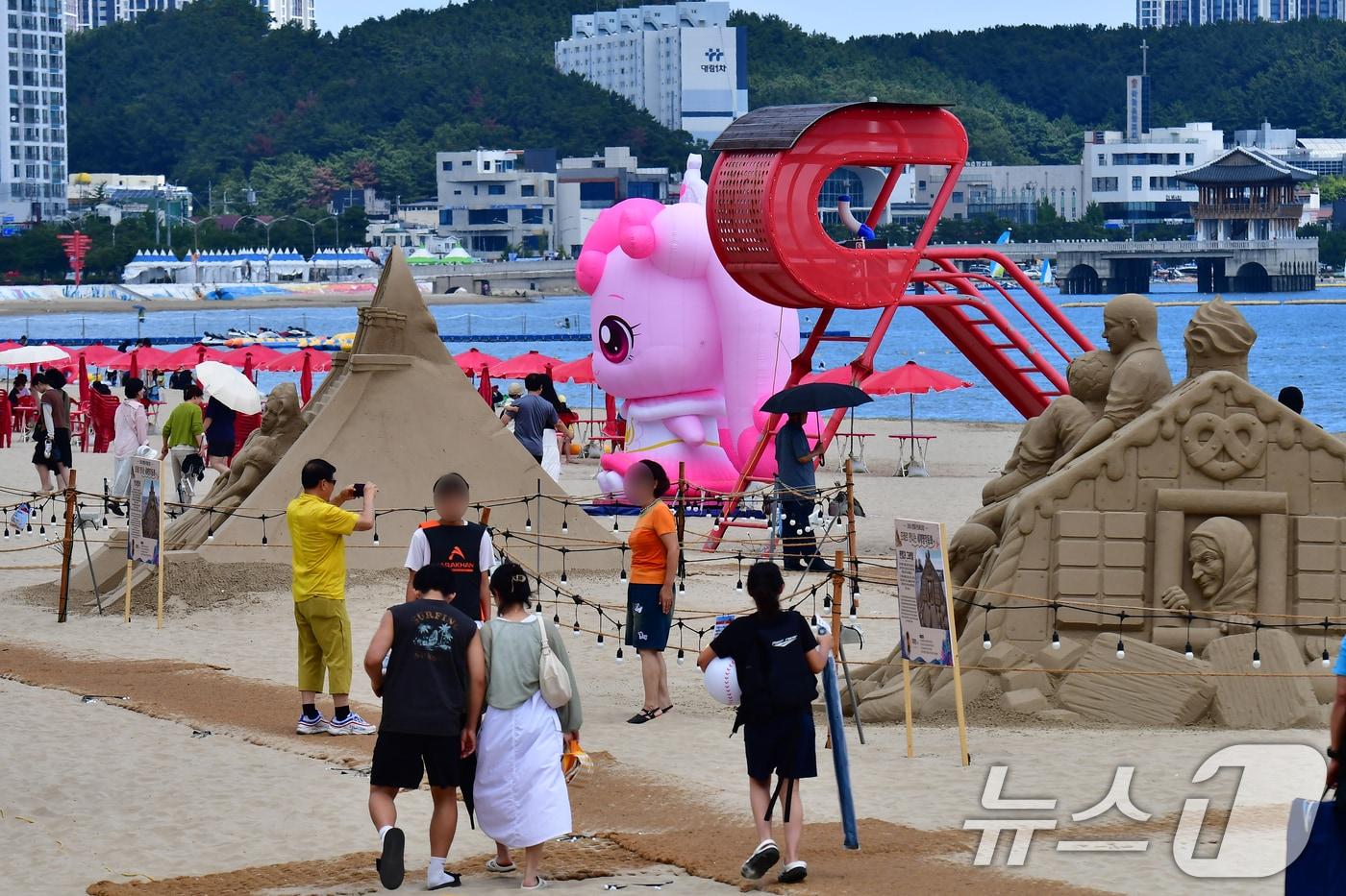 본문 이미지 - 26일 경북 포항시 영일대해수욕장에서 시민과 관광객들이 샌드페스티벌 모래조각 작품과 프린센스 캐치 티피닝 캐릭터를 둘러보고 있다. 2026.7.26 ⓒ 뉴스1 최창호 기자