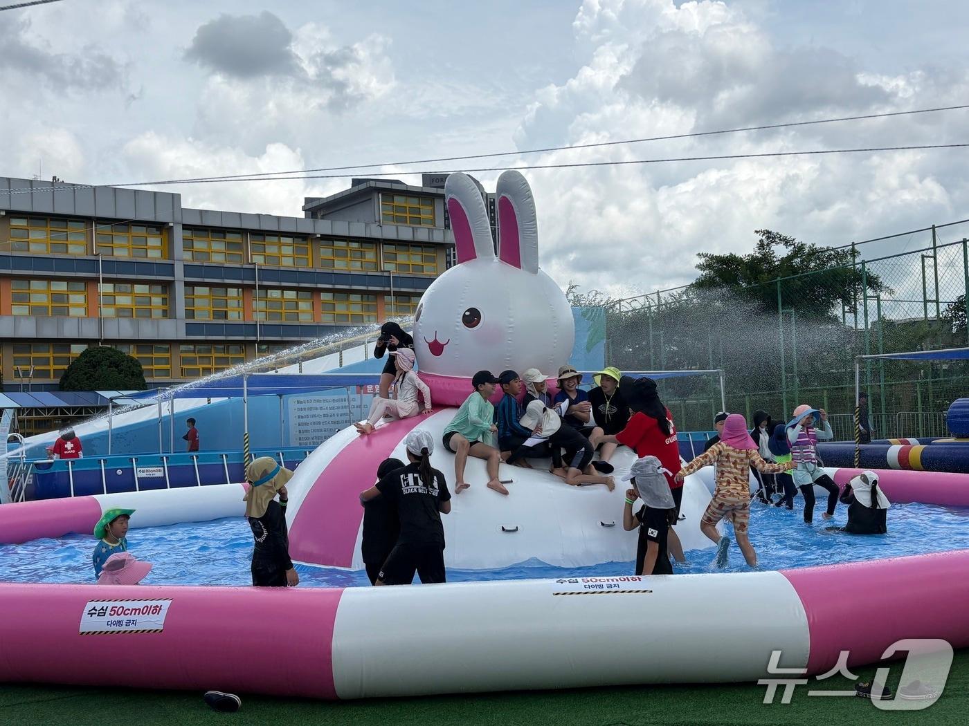 본문 이미지 -  27일 서울 강북구 송천초등학교 운동장에 마련된 물놀이장에서 어린이들이 물놀이를 즐기고 있다. 2026.7.27 ⓒ 뉴스1 소봄이 기자