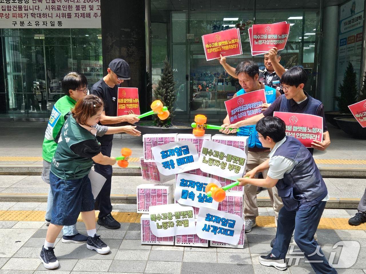 본문 이미지 - 전국민주노동조합총연맹(민주노총)이 27일 오전 서울 중구 고용노동부 서울지방고용노동청 앞에서 '도급제 노동자 최저임금 부결, 2027년 적용 최저임금 결정 이의제기 기자회견'을 열고 퍼포먼스를 진행 중인 모습. (전국민주노동조합총연맹 제공)