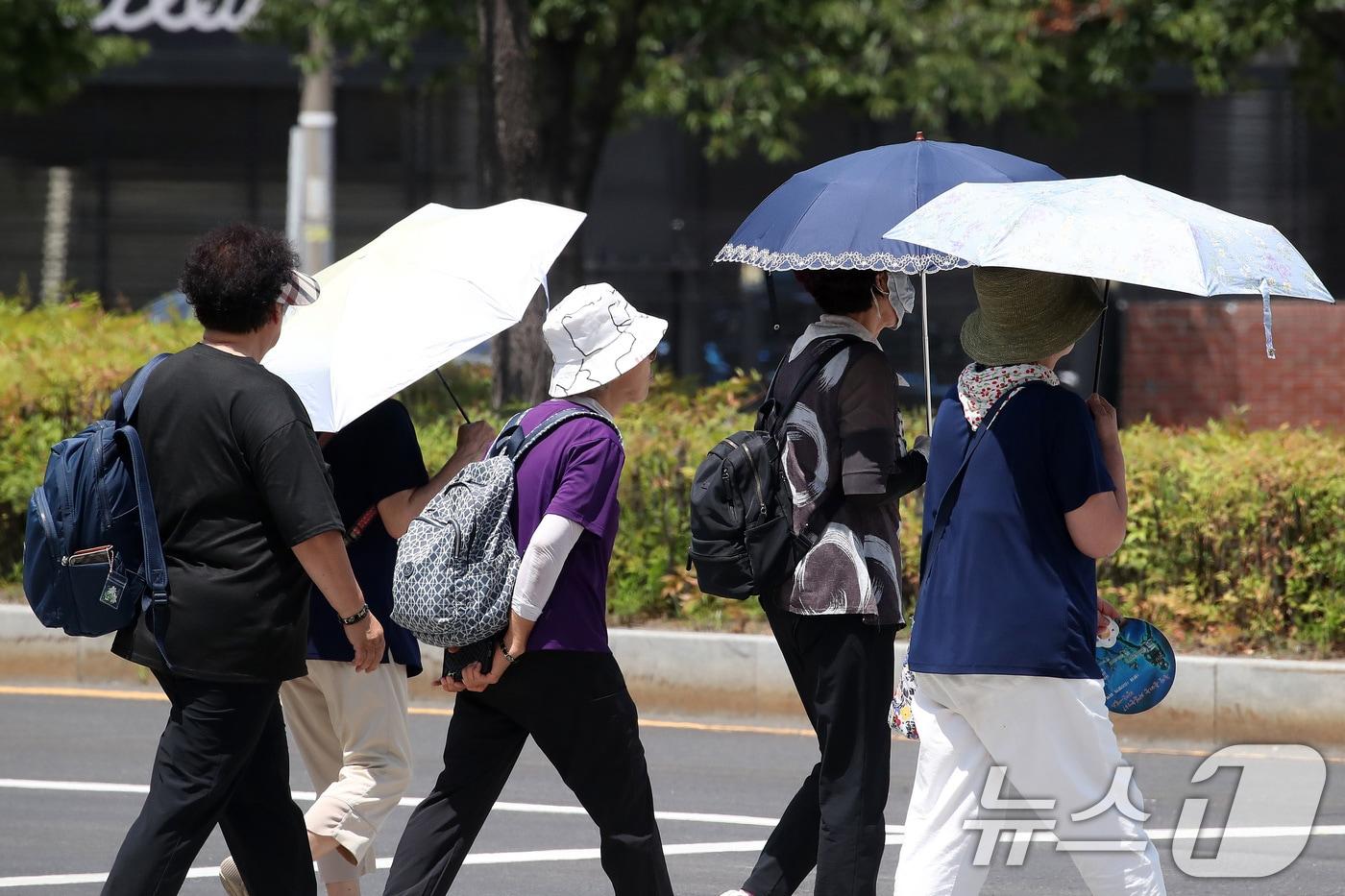 본문 이미지 - 폭염이 계속된 27일 대구 수성구 수성못 상화동산에서 시민들이 뙤약볕을 피하기 위해 양산을 쓴 시민들이 발걸음을 옮기고 있다. 2026.7.27 ⓒ 뉴스1 공정식 기자