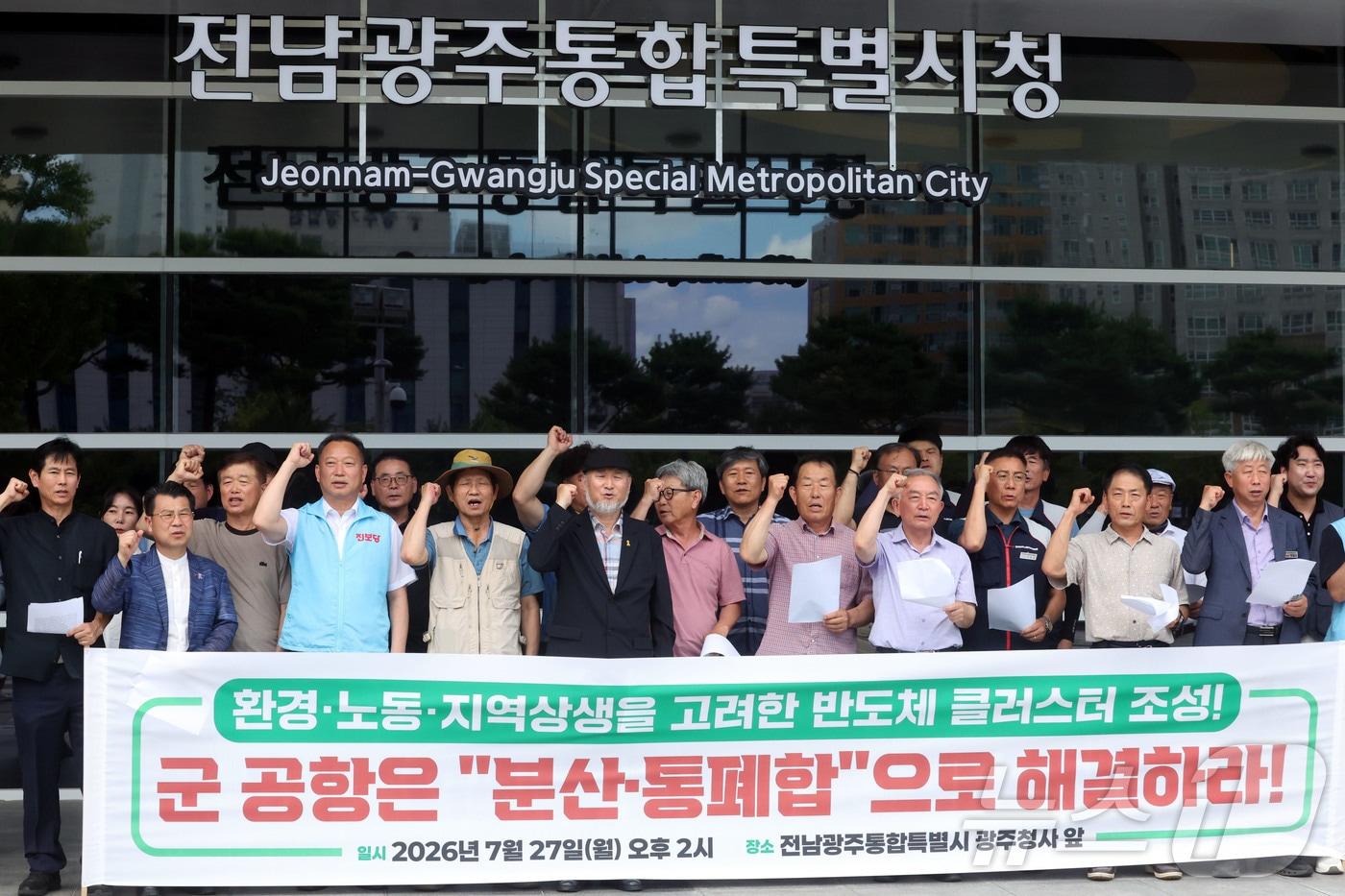 본문 이미지 - 전남광주 시민사회단체 관계자들이 27일 오후 전남광주통합특별시 광주청사 앞에서 '환경·노동·지역상생을 고려한 반도체 클러스터 조성 및 군 공항 분산·통폐합 해결 촉구 공동기자회견'을 열고 구호를 외치고 있다. 2026.7.27 ⓒ 뉴스1 조수민 기자