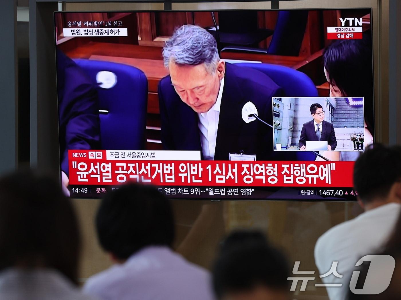 본문 이미지 - 27일 서울 용산구 서울역 대합실에서 시민들이 윤석열 전 대통령의 공직선거법 위반 혐의 1심 선고 생중계를 바라보고 있다. 이날 법원은 윤석열에게 징역 1년 6개월에 집행유예 3년을 선고했다. 2026.7.27 ⓒ 뉴스1 박지혜 기자