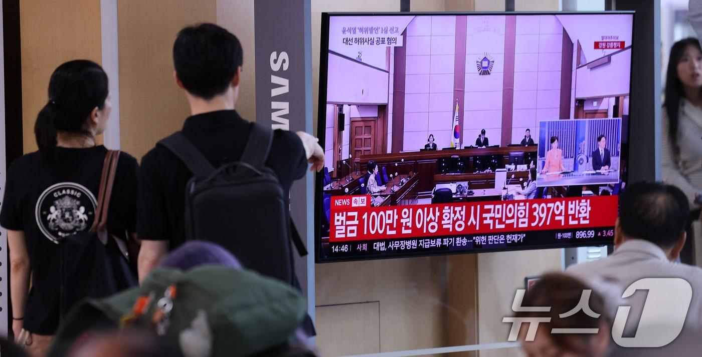 본문 이미지 - 27일 서울 용산구 서울역 대합실에서 시민들이 윤석열 전 대통령의 공직선거법 위반 혐의 1심 선고 생중계를 바라보고 있다. 이날 법원은 윤석열에게 징역 1년 6개월에 집행유예 3년을 선고했다. 2026.7.27 ⓒ 뉴스1 박지혜 기자