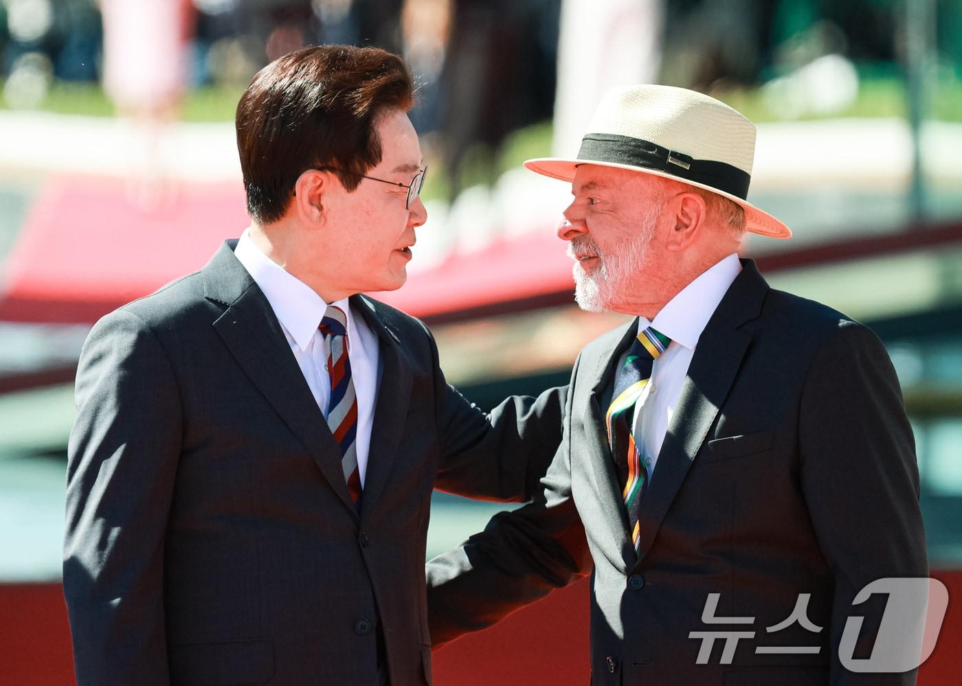 본문 이미지 - 이재명 대통령이 27일(현지시간) 브라질 대통령관저에서 열린 공식 환영식에서 루이스 이나시우 룰라 다 시우바 대통령과 대화를 하고 있다. 2026.7.27 ⓒ 뉴스1 허경 기자