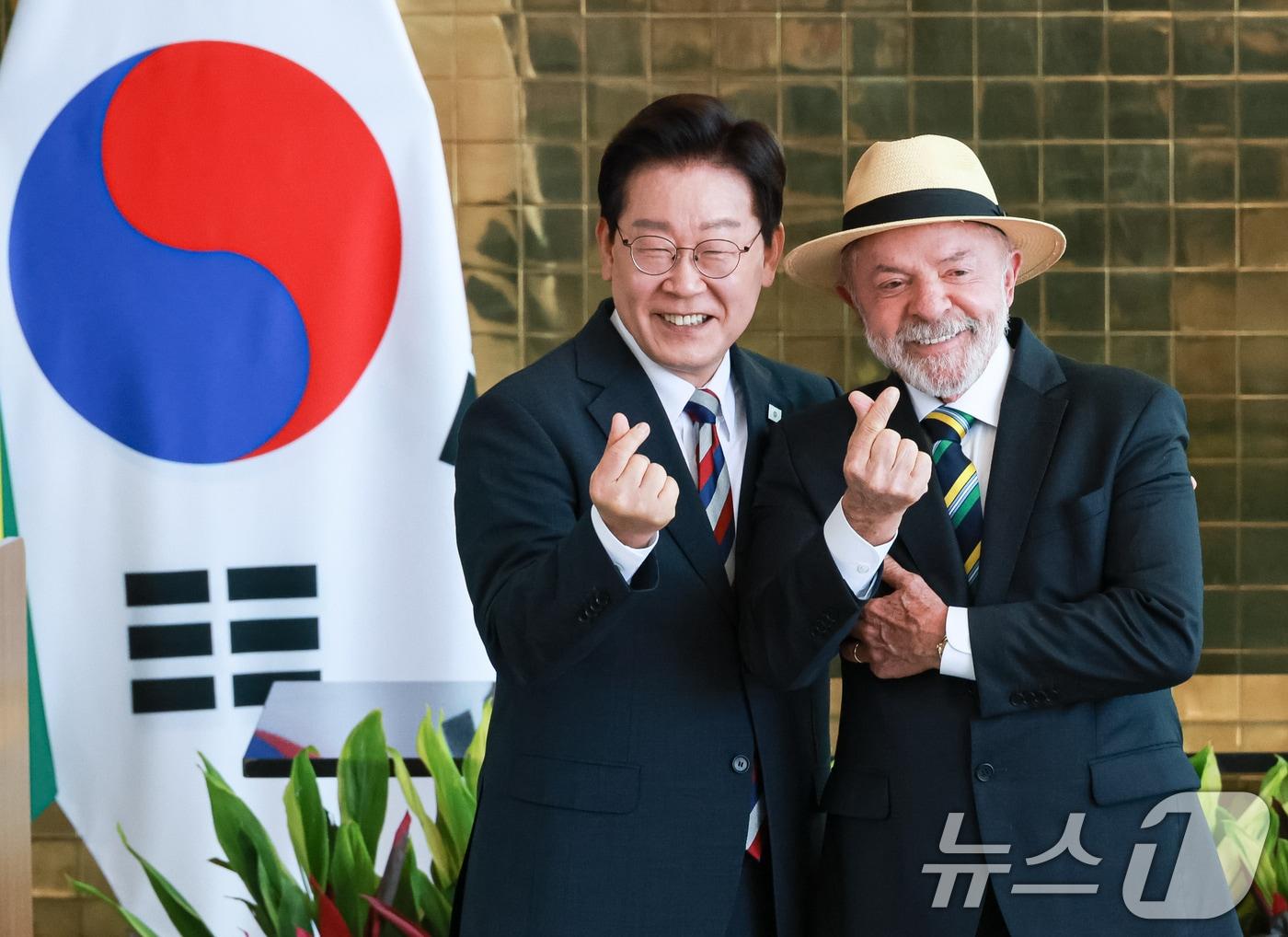 본문 이미지 - 이재명 대통령과 루이스 이나시우 룰라 다 시우바 브라질 대통령이 27일(현지시간) 브라질 대통령관저에서 공동언론발표를 마친 후 손하트를 만들어 보이고 있다. 2026.7.28 ⓒ 뉴스1 허경 기자