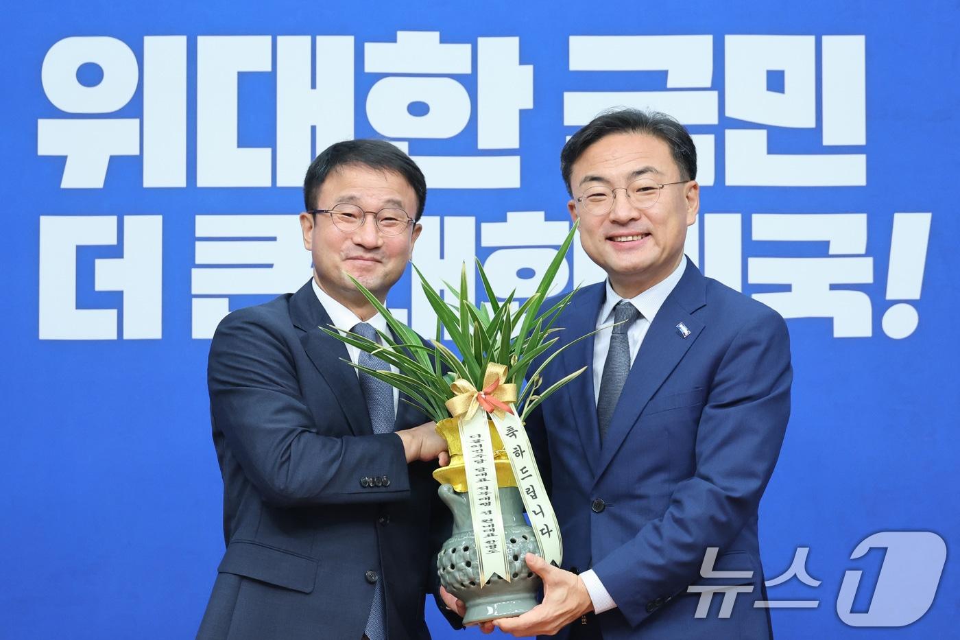 본문 이미지 - 신장식 조국혁신당 대표가 28일 서울 여의도 국회에서 한병도 더불어민주당 대표 직무대행 겸 원내대표를 예방하며 축하난을 선물받고 있다. 2026.7.28 ⓒ 뉴스1 신웅수 기자