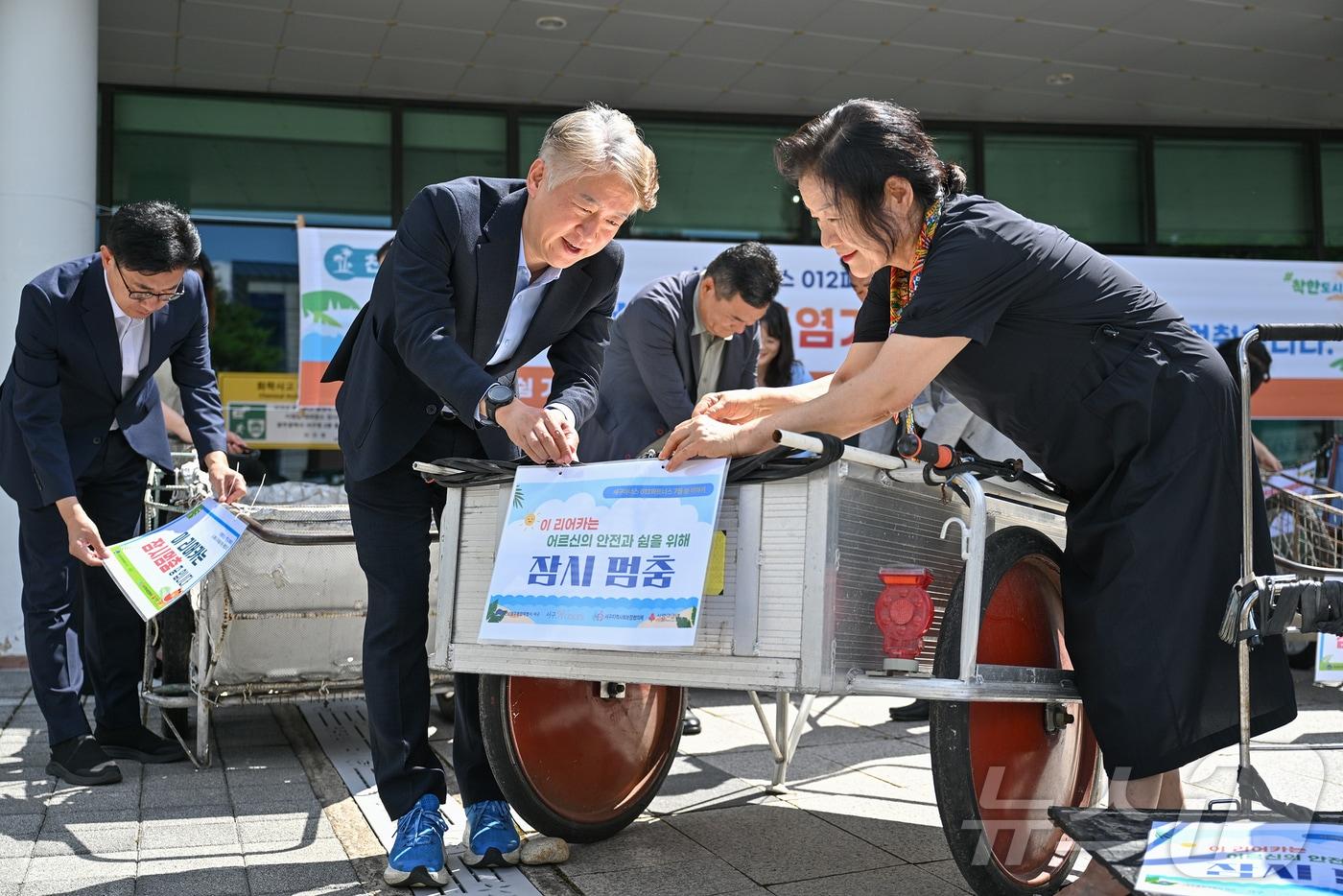 본문 이미지 - 전남광주통합특별시 서구청 관계자들이 28일 구청 야외광장에서 폭염 속 폐지수집 어르신들의 안전을 위해 손수레(리어카)를 보관하고 혹서기 쉼 권장 안내문을 부착하고 있다.(전남광주통합특별시 서구 제공. 재판매 및 DB 금지) 2026.7.28 