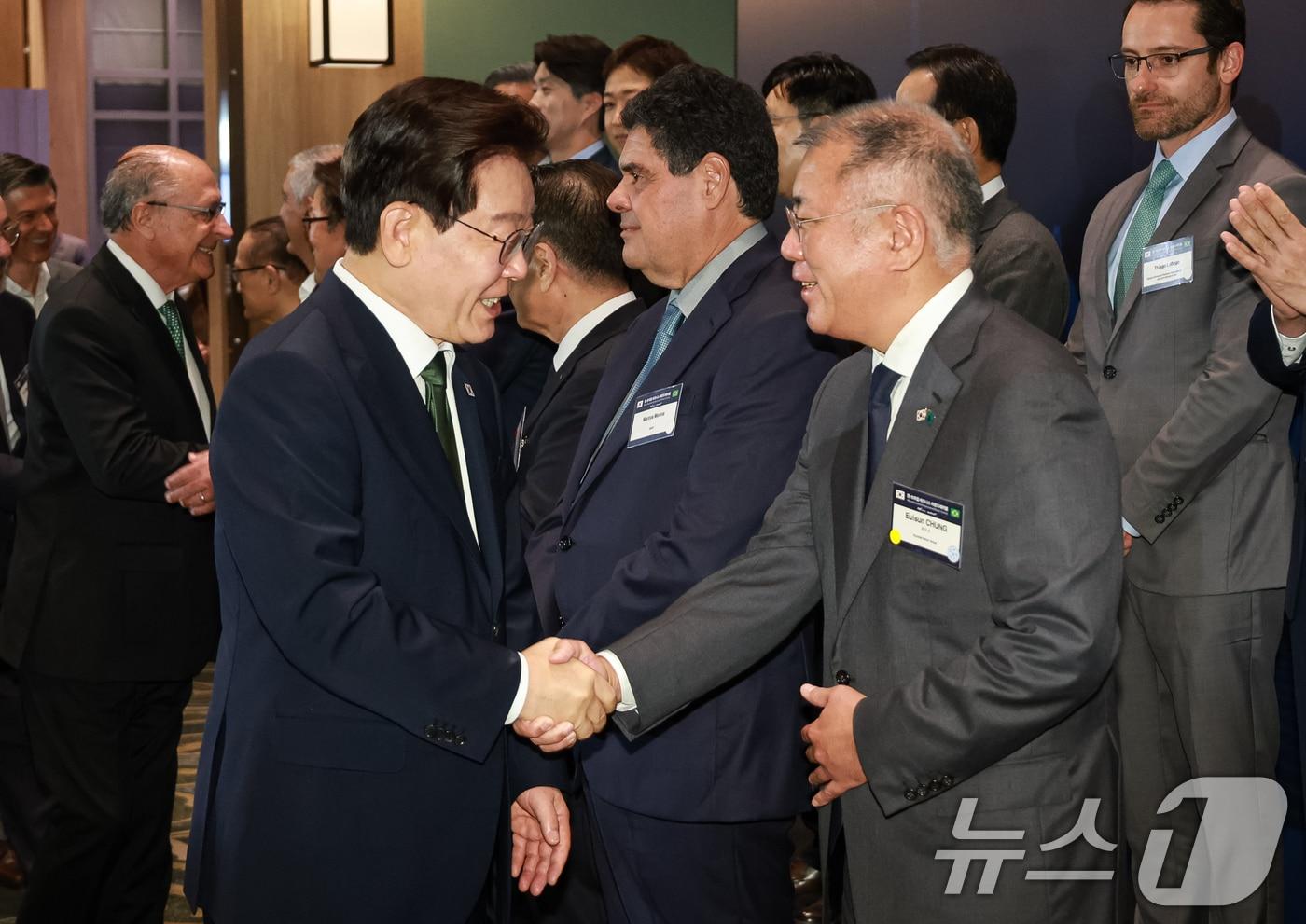 본문 이미지 - 이재명 대통령과 정의선 현대차그룹 회장이 지난 7월 28일(현지시간) 브라질 상파울루 한 호텔에서 열린 비즈니스 라운드테이블에서 인사를 나누고 있다. 2026.7.29 ⓒ 뉴스1 허경 기자