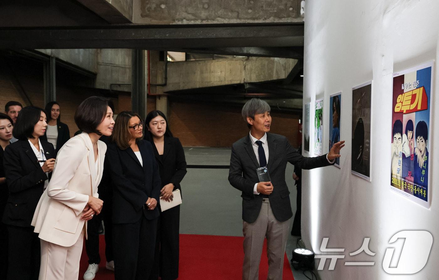 본문 이미지 - 김혜경 여사와 호잔젤라 다시우바 여사가 28일(현지시간) 브라질 상파울루 시립문화센터에서 열린 한국영화제 특별세션에서 관계자로부터 설명을 듣고 있다. 2026.7.29 ⓒ 뉴스1 허경 기자