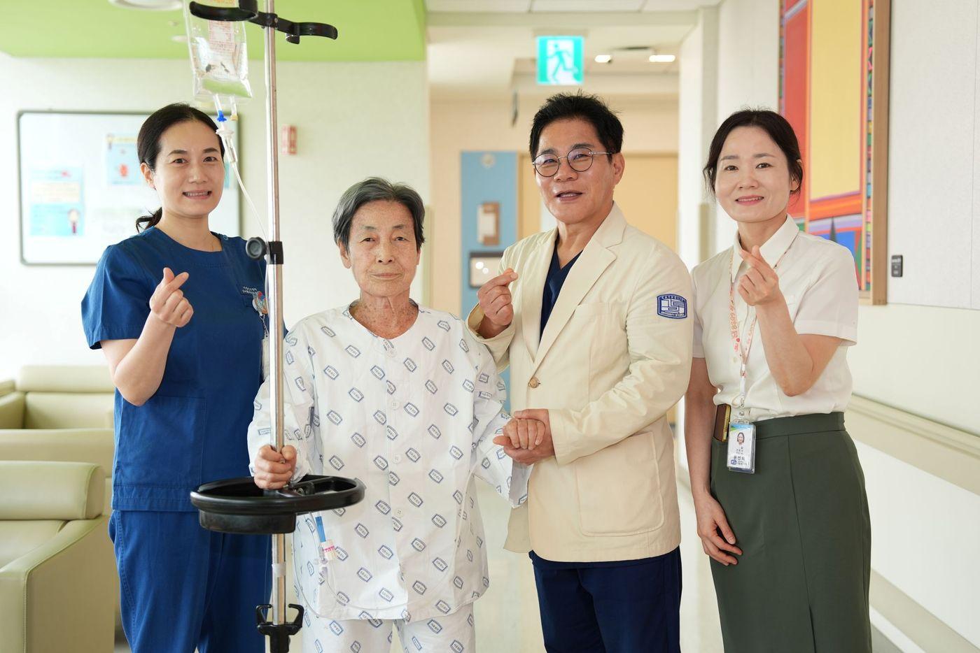 본문 이미지 - 국내 최초 차세대 TAVI 재시술 기법인 '라마콘'(LLAMACORN) 시술을 성공적으로 받은 환자와 서울성모병원 심뇌혈관병원 장기육 교수(오른쪽 두 번째), 의료진이 기념촬영을 하고 있다. (병원 제공)