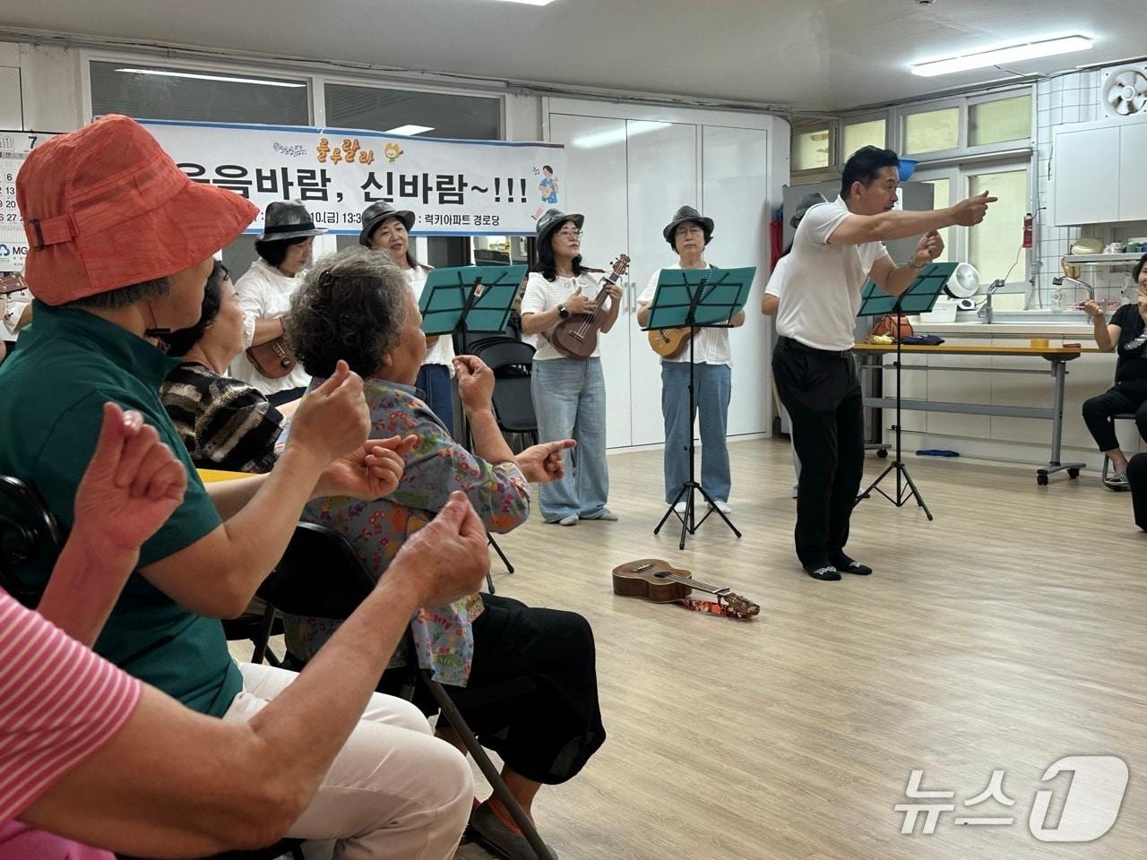 본문 이미지 - 지난 7월 '룰루랄라' 봉사단이 럭키아파트 경로당에서 우쿨렐레 공연을 진행하고 있다.(금천구 제공)