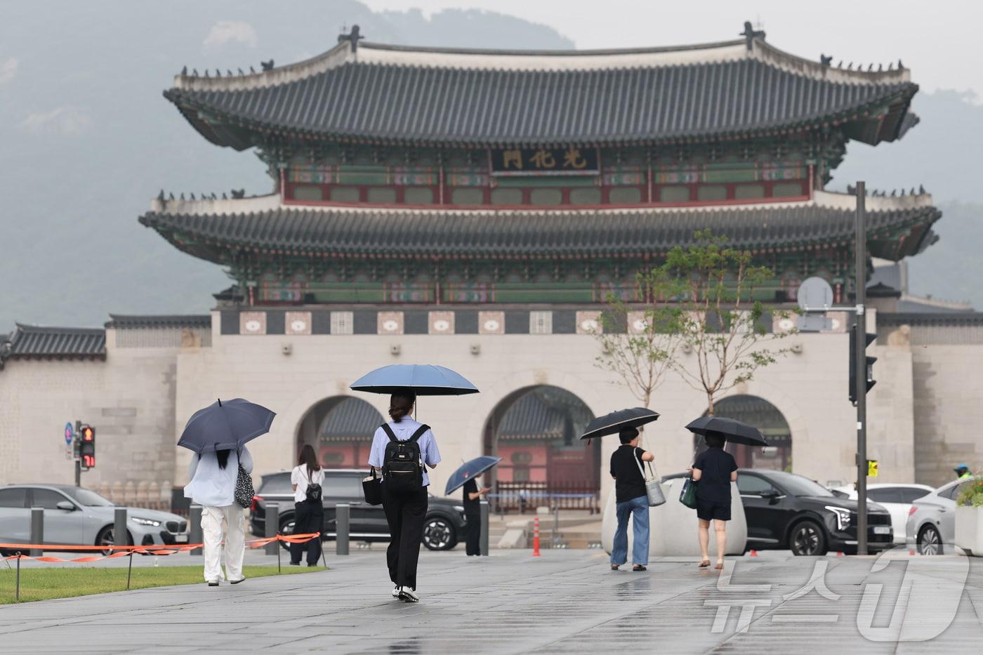본문 이미지 - 비가 내린 3일 오전 서울 종로구 광화문광장에서 시민들이 우산을 쓰고 이동하고 있다. 2026.7.3 ⓒ 뉴스1 이종수 기자