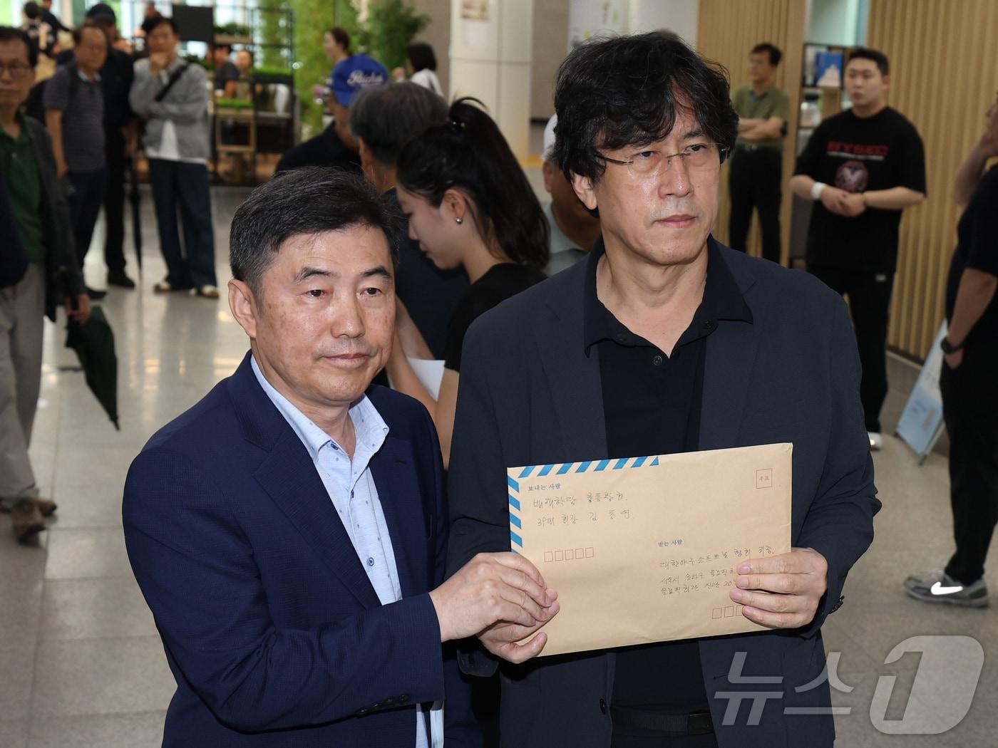 본문 이미지 - 김동연 배재학당 총동창회장(오른쪽)이 3일 서울 송파구 올림픽회관에서 배재고 야구부의 5·18 민주화운동 폄훼 논란과 관련해 대한야구소프트볼협회에 제출할 대국민 탄원서를 들어 보이고 있다. ⓒ 뉴스1 이종수 기자