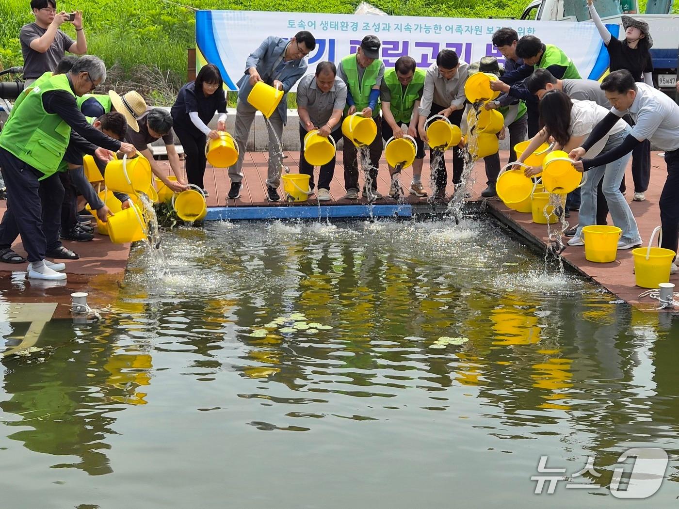 본문 이미지 - 경남도 수산자연연구소 민물고기연구센터 관계자들이 3일 창원시 산남저수지에서 어린 메기를 방류하고 있다.(경남도 제공. 재판매 및 DB금지)
