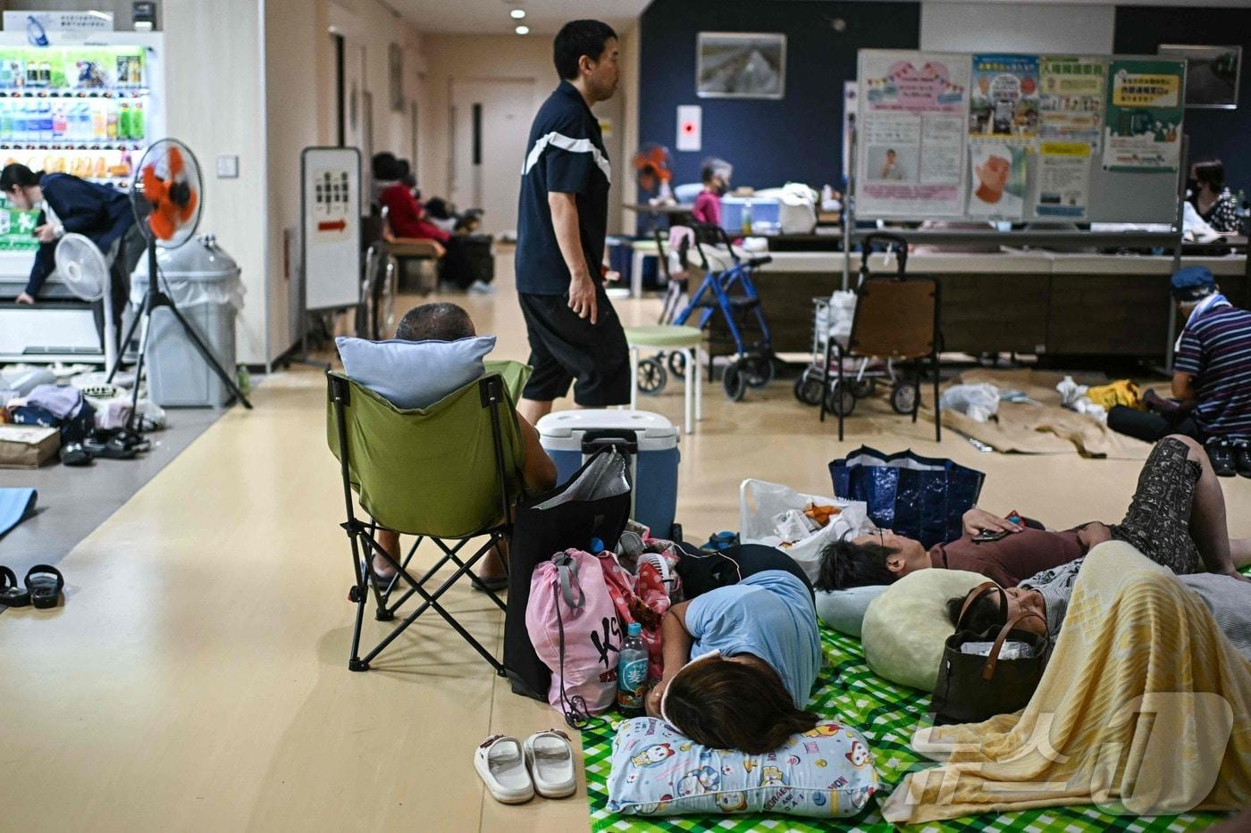 본문 이미지 - 29일 일본 구마모토현 우키시의 대피소에서 이재민들이 휴식을 취하고 있다. 구마모토현에 따르면 지난 28일 발생한 이번 지진으로 인한 사망자는 총 17명으로 집계됐다. 2026.07.29 ⓒ AFP=뉴스1