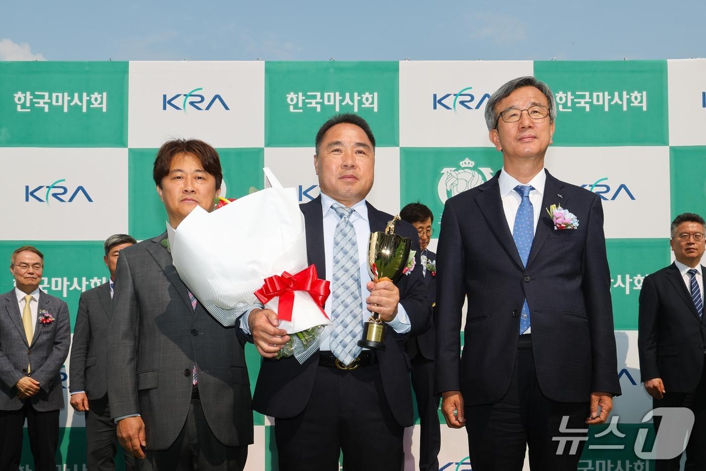 본문 이미지 - 백광열 조교사(가운데)가 2025년 코리안더비 시상식에서 기념촬영을 하고 있다.(렛츠런파크 부산경남 제공. 재판매 및 DB금지)