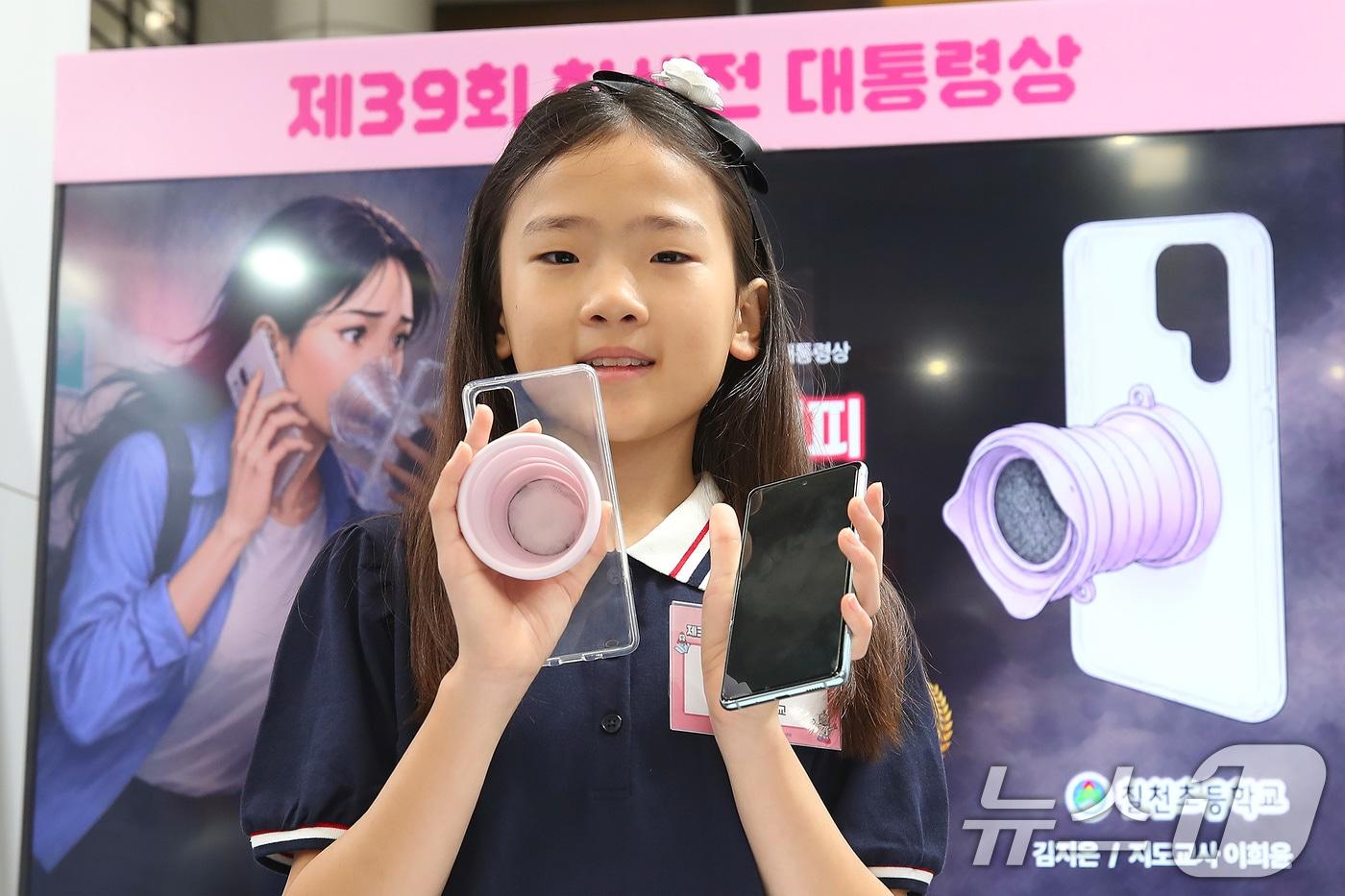 본문 이미지 - 30일 대구 북구 엑스코(EXCO)에서 개막한 '2026 청소년 발명 페스티벌'에서 경남 거제시 칠천초등학교 5학년 김지온 학생이 자신의 발명품인 '초기화재 대피 호흡 그립톡'을 선보이고 있다. 평소 스마트폰 케이스 뒷면에 붙여 그립톡으로 사용하다 화재 시 마스크로 활용할 수 있게 만든 이 발명품은 제39회 대한민국학생발명전시회에서 최고상인 대통령상을 차지했다. 2026.7.30 ⓒ 뉴스1 공정식 기자