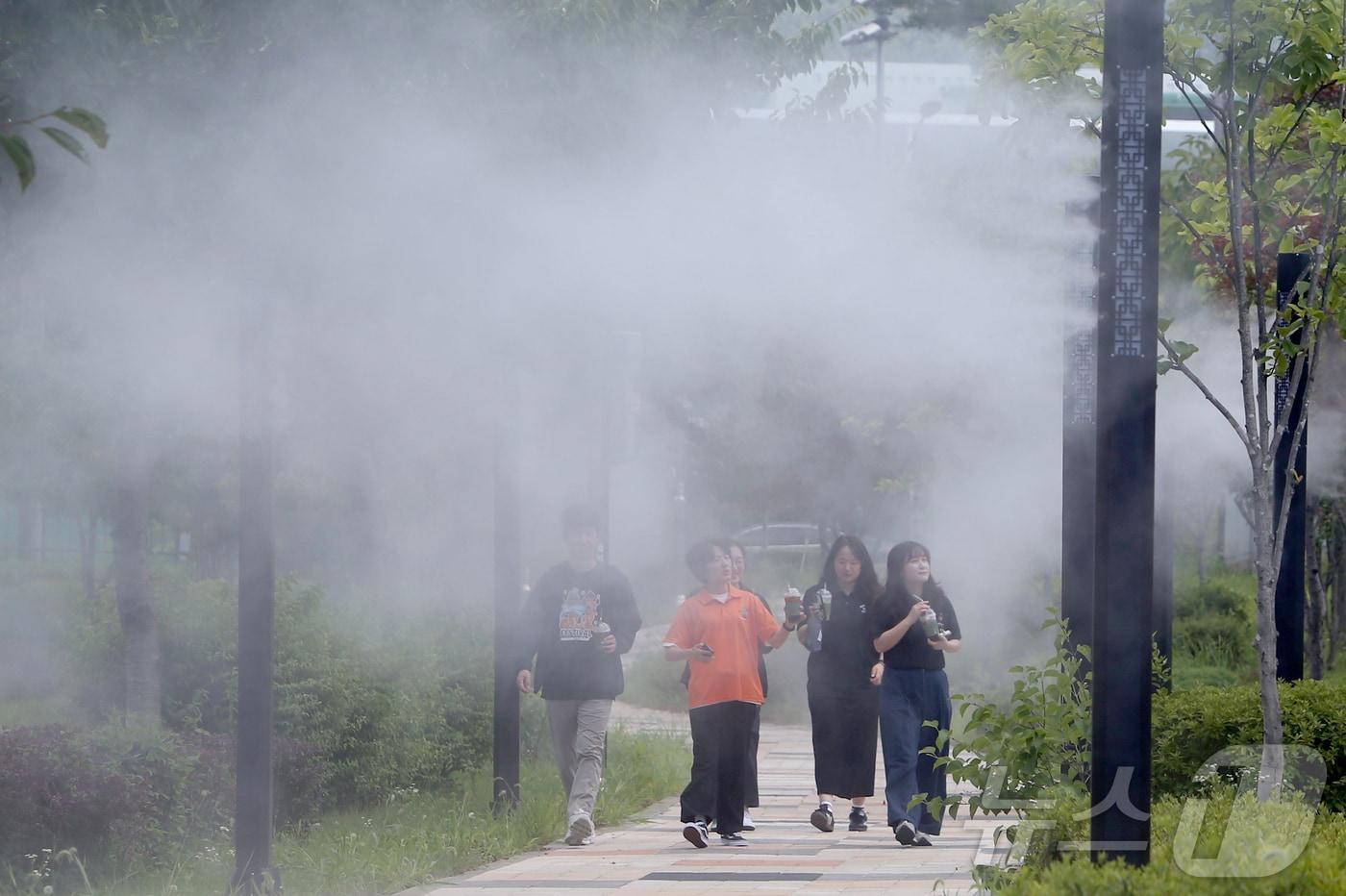 본문 이미지 - 31일 폭염특보가 발효된 대전·충남은 낮 최고 체감온도가 33도 이상까지 오르는 무더위가 이어질 것으로 예보됐다.충남 보령시 명천동 산책로에 쿨링포그가 설치돼 지나는 시민들이 더위를 식히고 있다. ⓒ 뉴스1 김기태 기자