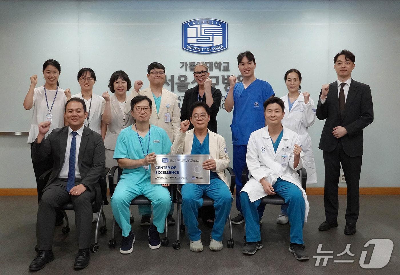 본문 이미지 - 가톨릭대 서울성모병원 관계자들과 글로벌 헬스케어 기업 애보트사 관계자들이 지난 29일 병원에서 열린 'TAVI 분야 아시아·태평양 지역 우수센터(APAC COE)' 자격 획득 기념 현판식을 마친 후 기념사진을 촬영하고 있다.(가톨릭대 서울성모병원 제공)