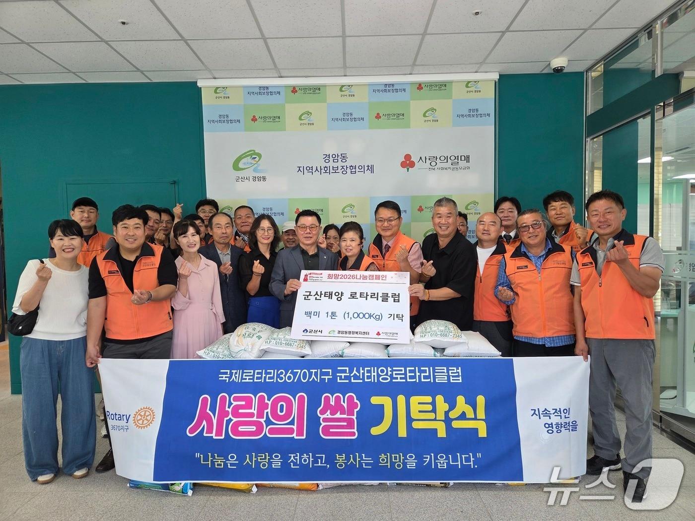 본문 이미지 - 군산태양로타리클럽 회원들이 31일 군산시 경암동 행정복지센터에 백미를 기탁했다.(군산시 제공. 재판매 및 DB금지)
