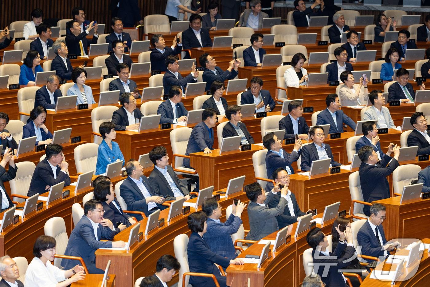 본문 이미지 - 31일 서울 여의도 국회에서 열린 제437회 국회(임시회) 제3차 본회의에서 형사소송법 일부개정법률안(대안)이 재석 178인 중 찬성 175인, 반대 2인으로 가결되자 여당 의원들이 휴대전화로 본회의장 전광판을 촬영하고 있다. 2026.7.31 ⓒ 뉴스1 유승관 기자