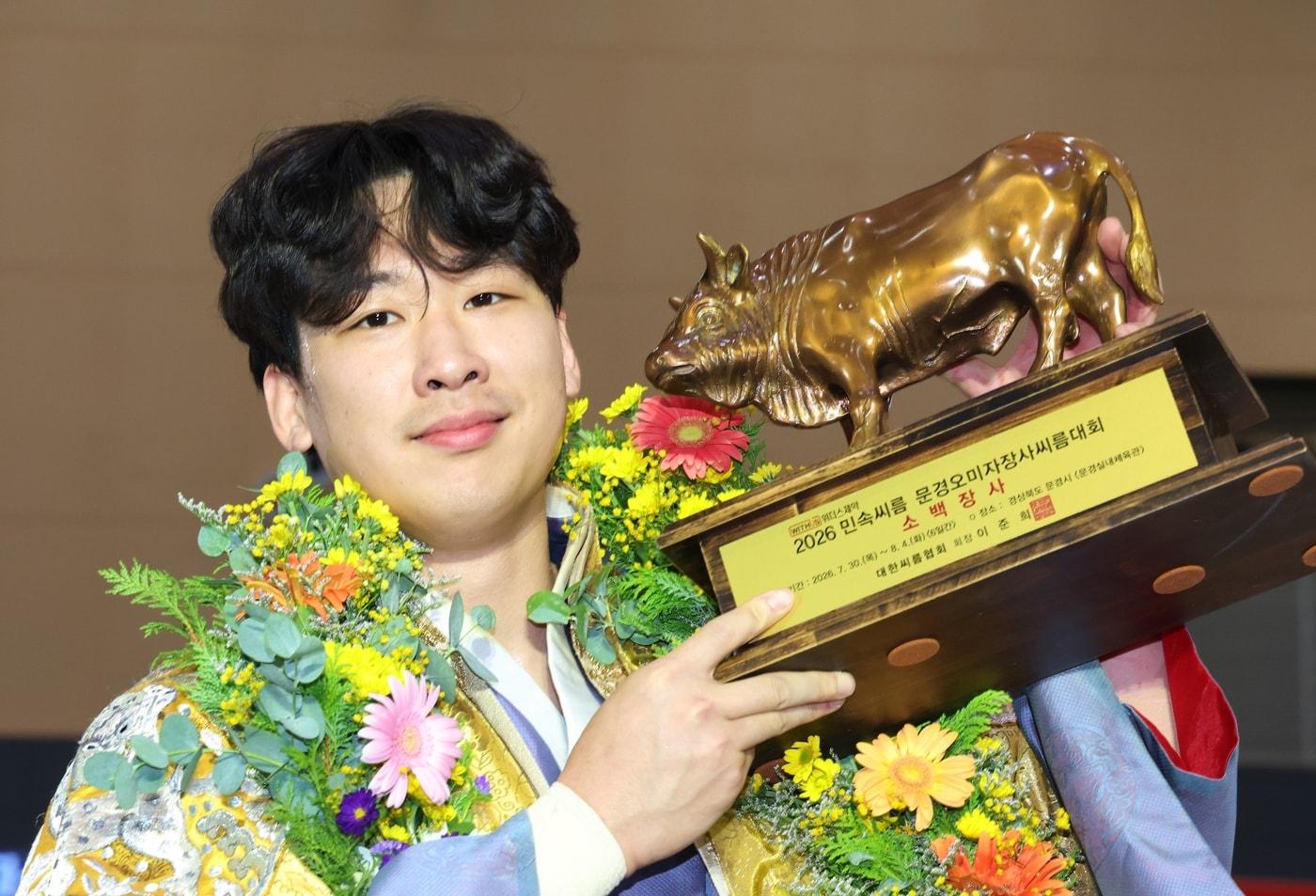 본문 이미지 - 31일 경상북도 문경시 문경실내체육관에서 열린 '위더스제약 2026 민속씨름 문경오미자장사씨름대회' 소백장사에 등극한 정우현이 황소트로피를 들고 기념사진을 찍고 있다. (대한씨름협회 제공)