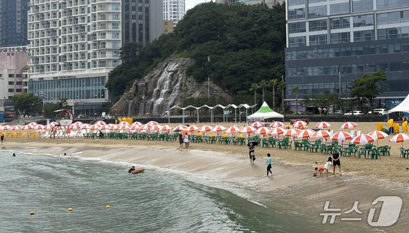 본문 이미지 - 5일 낮 부산 서구 송도해수욕장에서 피서객들이 부슬비 속에서도 물놀이를 즐기고 있다. 2026.7.5 ⓒ 뉴스1 박서현 기자