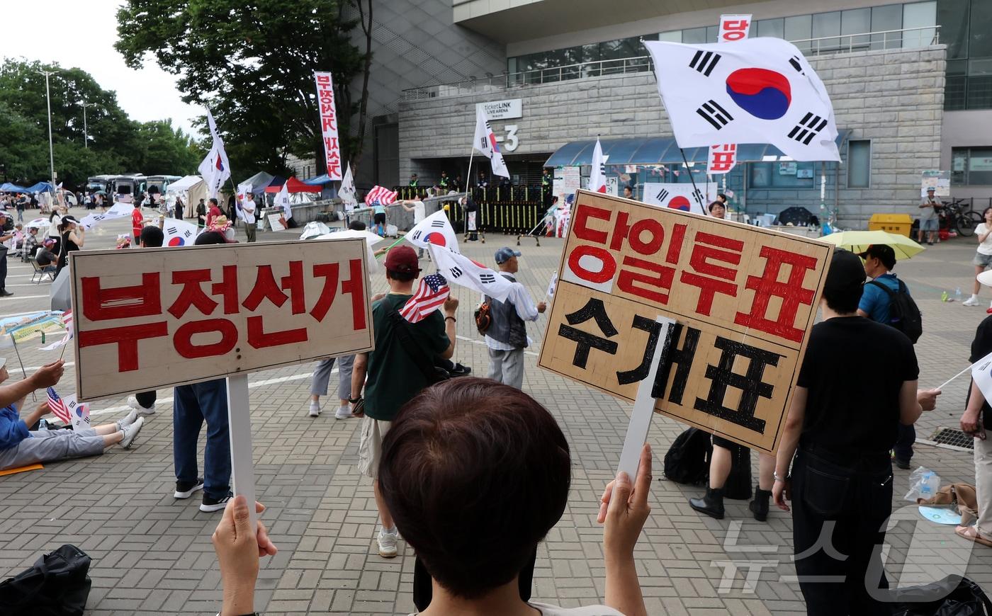 본문 이미지 - 6·3 지방선거 투표용지 부족사태로 인한 '잠실 봉쇄시위'가 계속되고 있는 5일 서울 송파구 올림픽공원 핸드볼경기장 인근에서 참가자들이 재선거를 요구하는 구호를 외치고 있다. 2026.7.5 ⓒ 뉴스1 김진환 기자