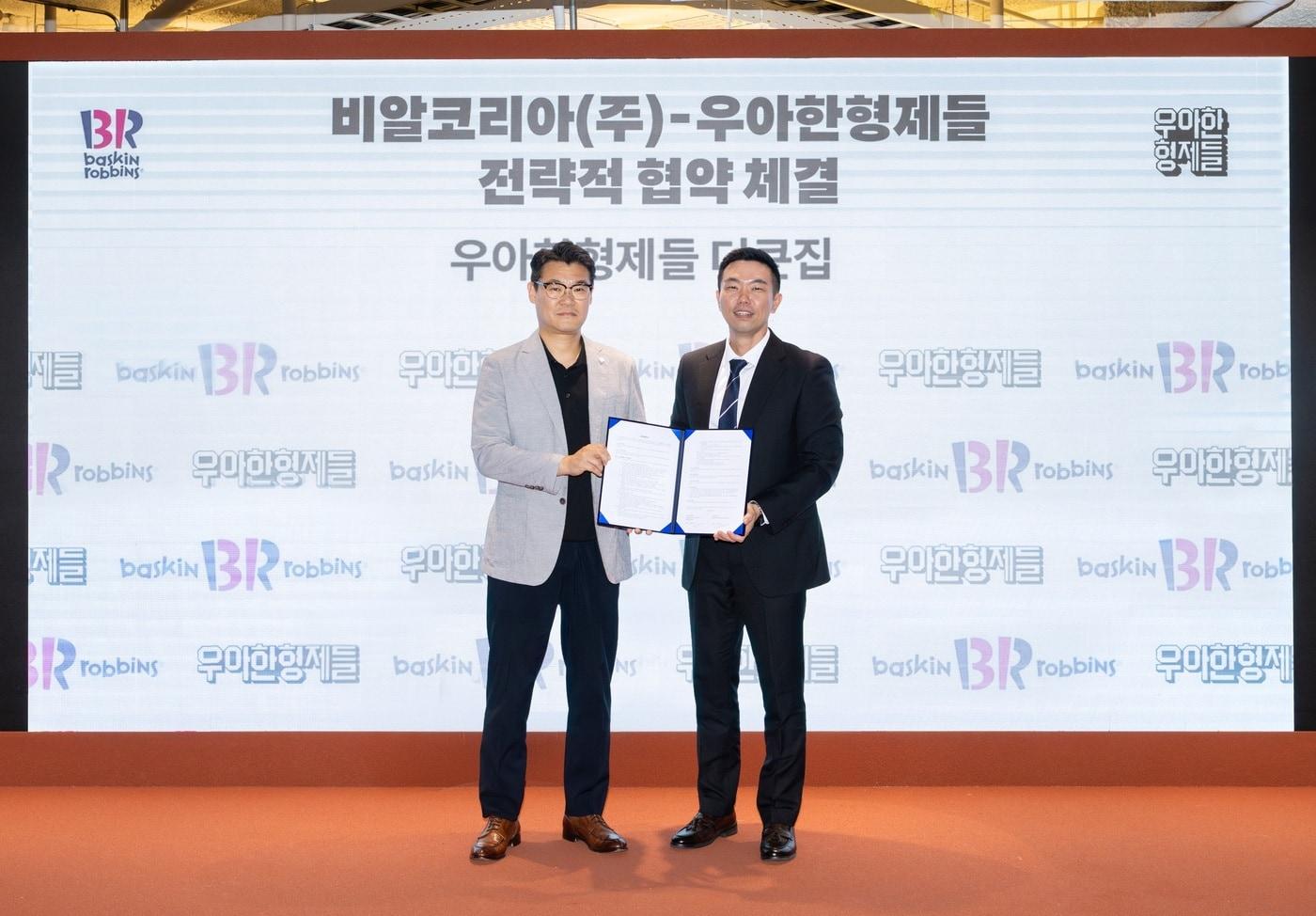 본문 이미지 - 김지훈 우아한형제들 사업부문장(오른쪽)과 윤문건 배스킨라빈스 커머스마케팅실장이 지난달 서울 송파구 우아한형제들 본사에서 전략적 업무 협약(MOU)을 체결한 뒤 기념 촬영을 하고 있다. (우아한형제들 제공)