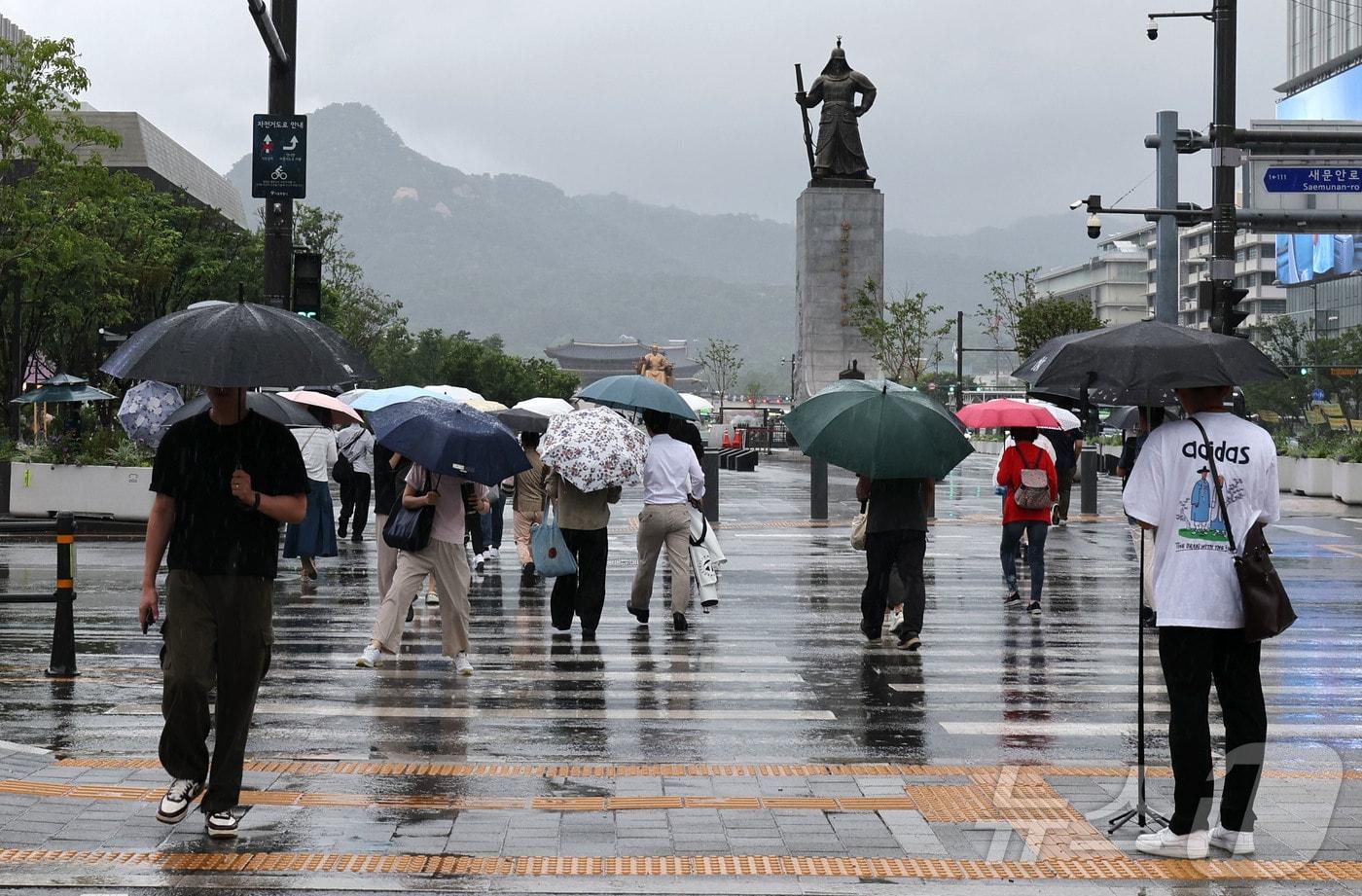 본문 이미지 - 비가 내리고 있는 6일 오전 서울 종로구 세종대로 사거리에서 우산을 쓴 시민들이 이동하고 있다. 2026.7.6 ⓒ 뉴스1 이종수 기자