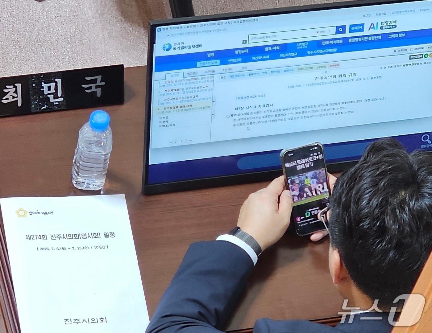 본문 이미지 - 최민국 진주시의원이 6일 시의회 본회의장에서 열린 의장 선거 중 휴대전화로 축구 동영상을 시청하고 있다. 2026.7.6/뉴스1 한송학기자